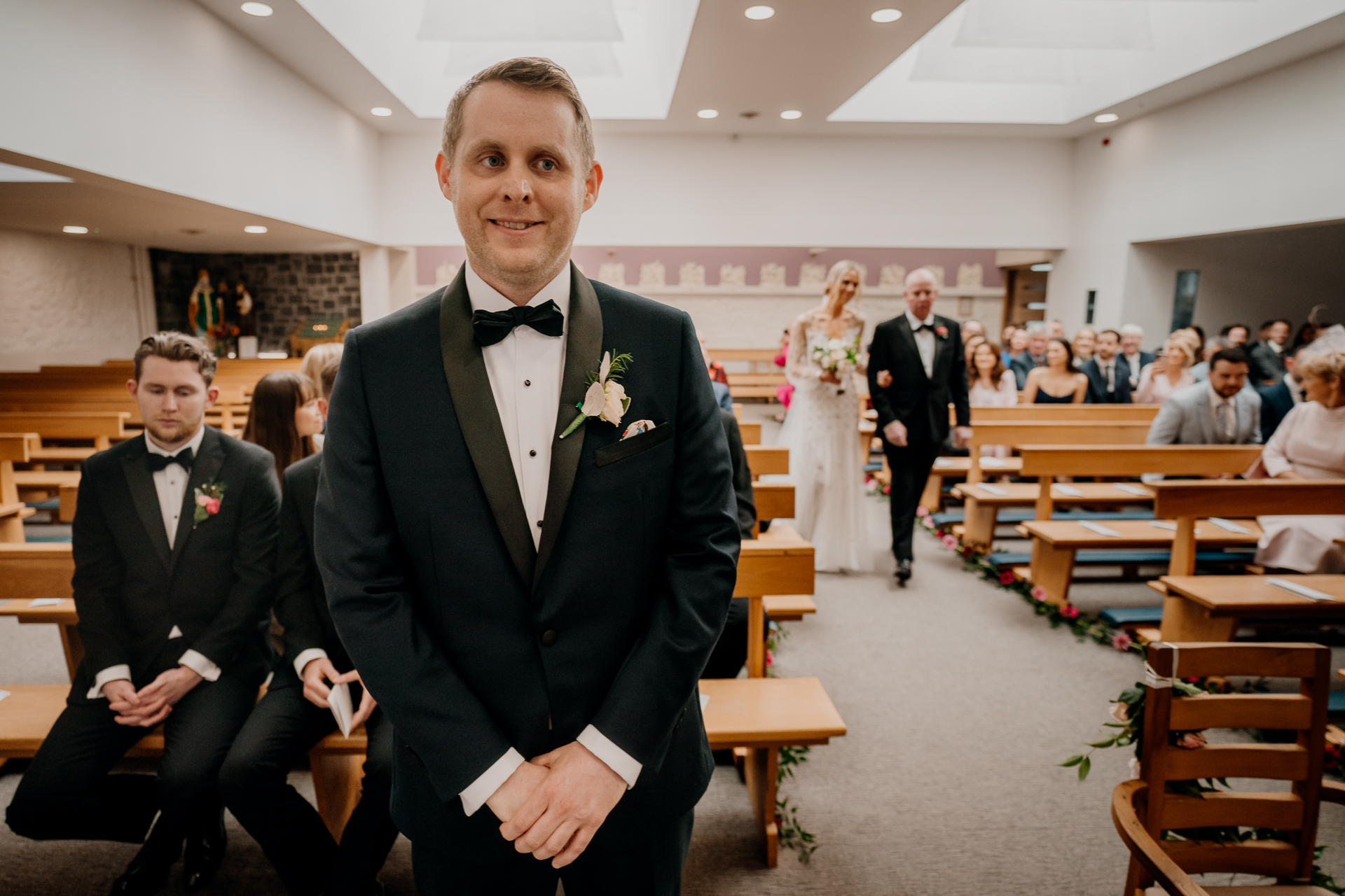 A man in a suit and bow tie in a church