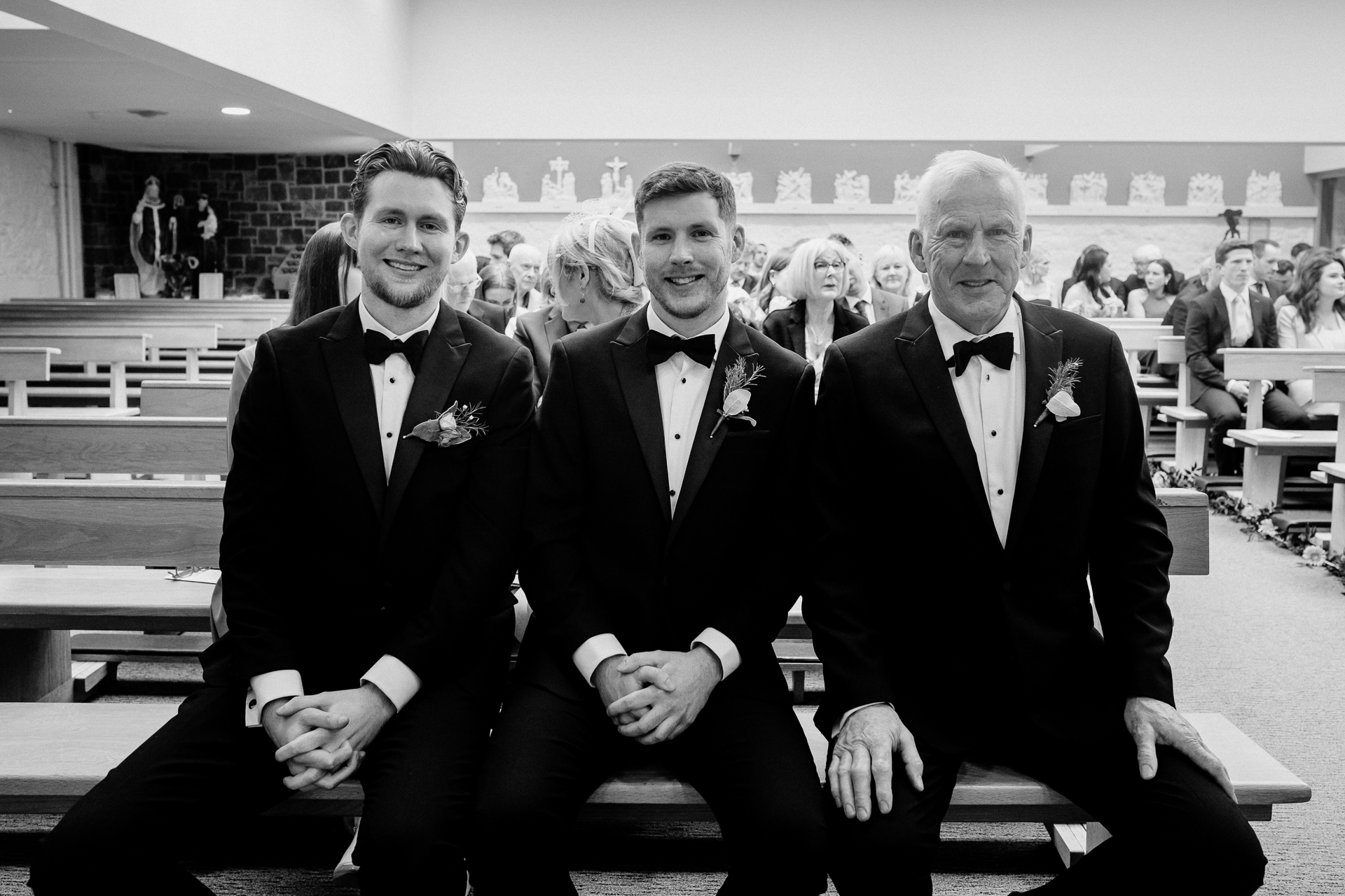 A group of men in suits sitting on a bench