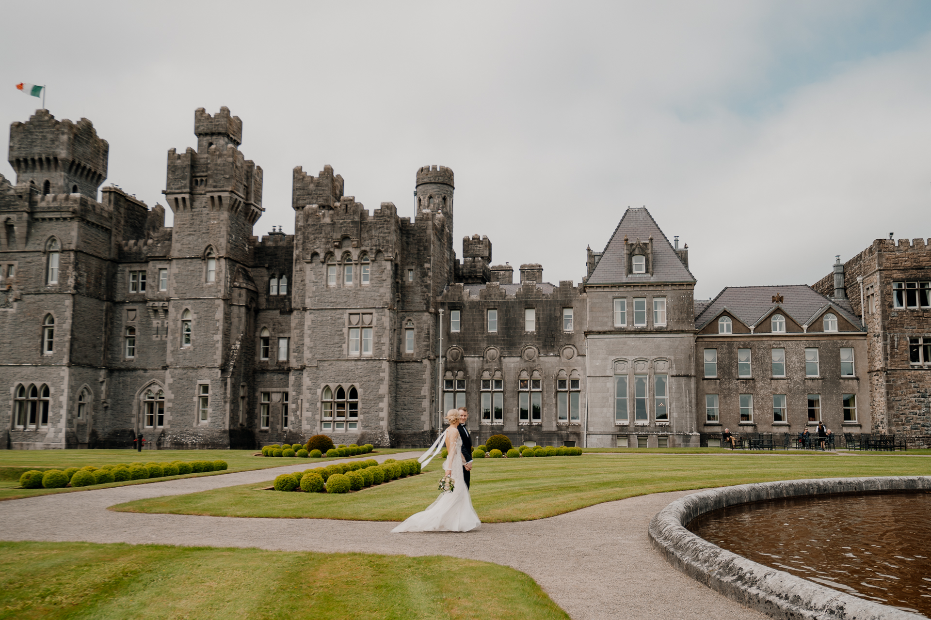 A person in a white dress in front of a large castle