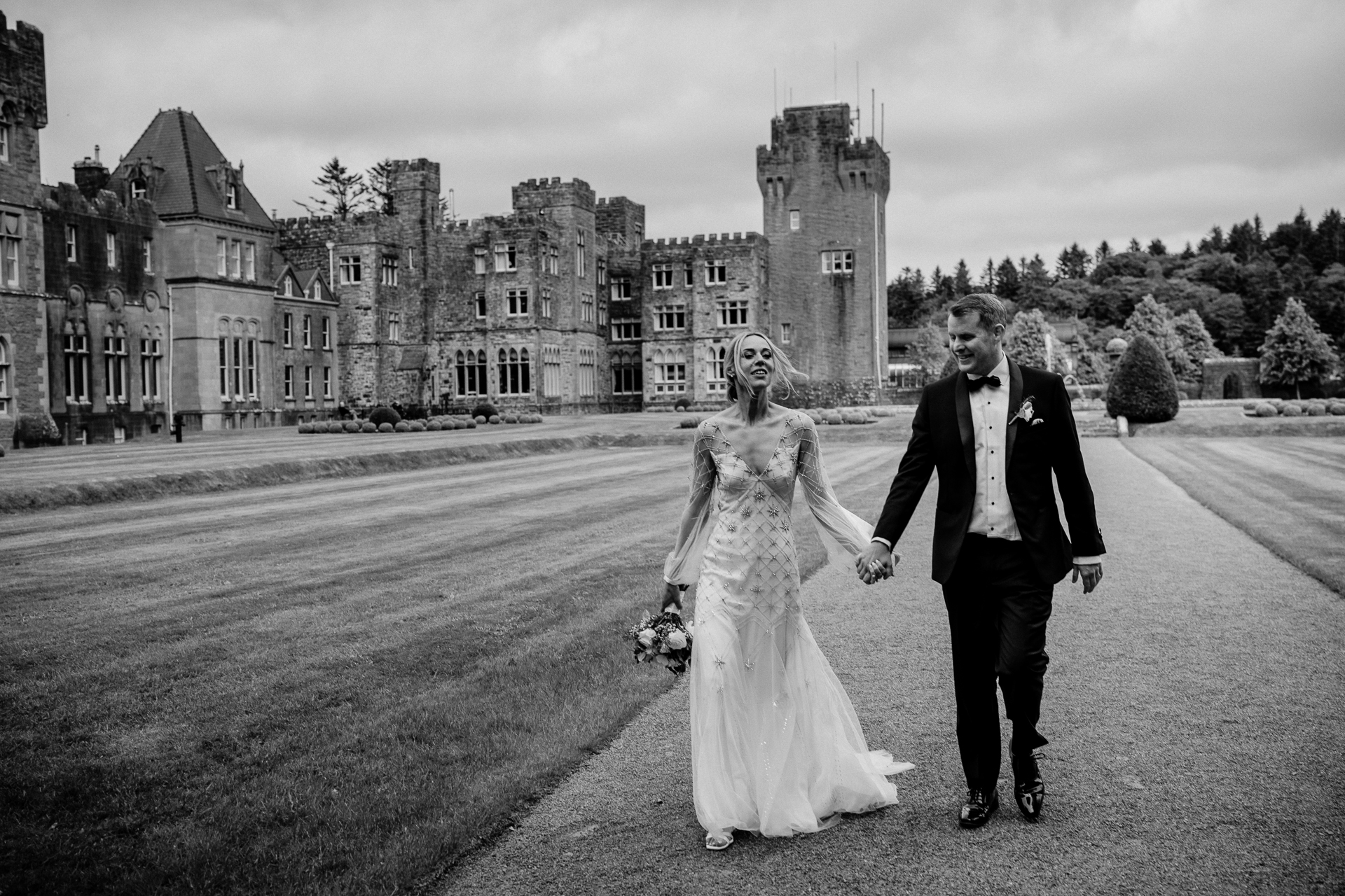 A man and woman walking down a road in front of a castle