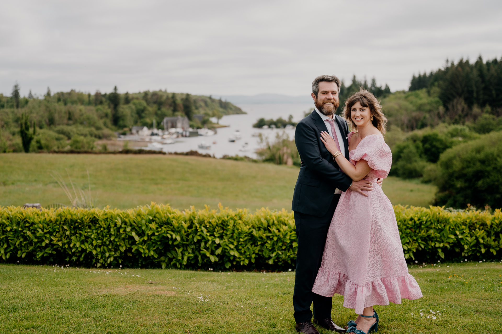 A man and woman posing for a picture in front of a lake