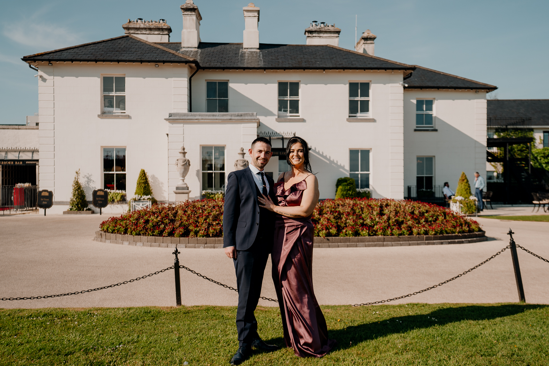 A man and woman posing in front of a house