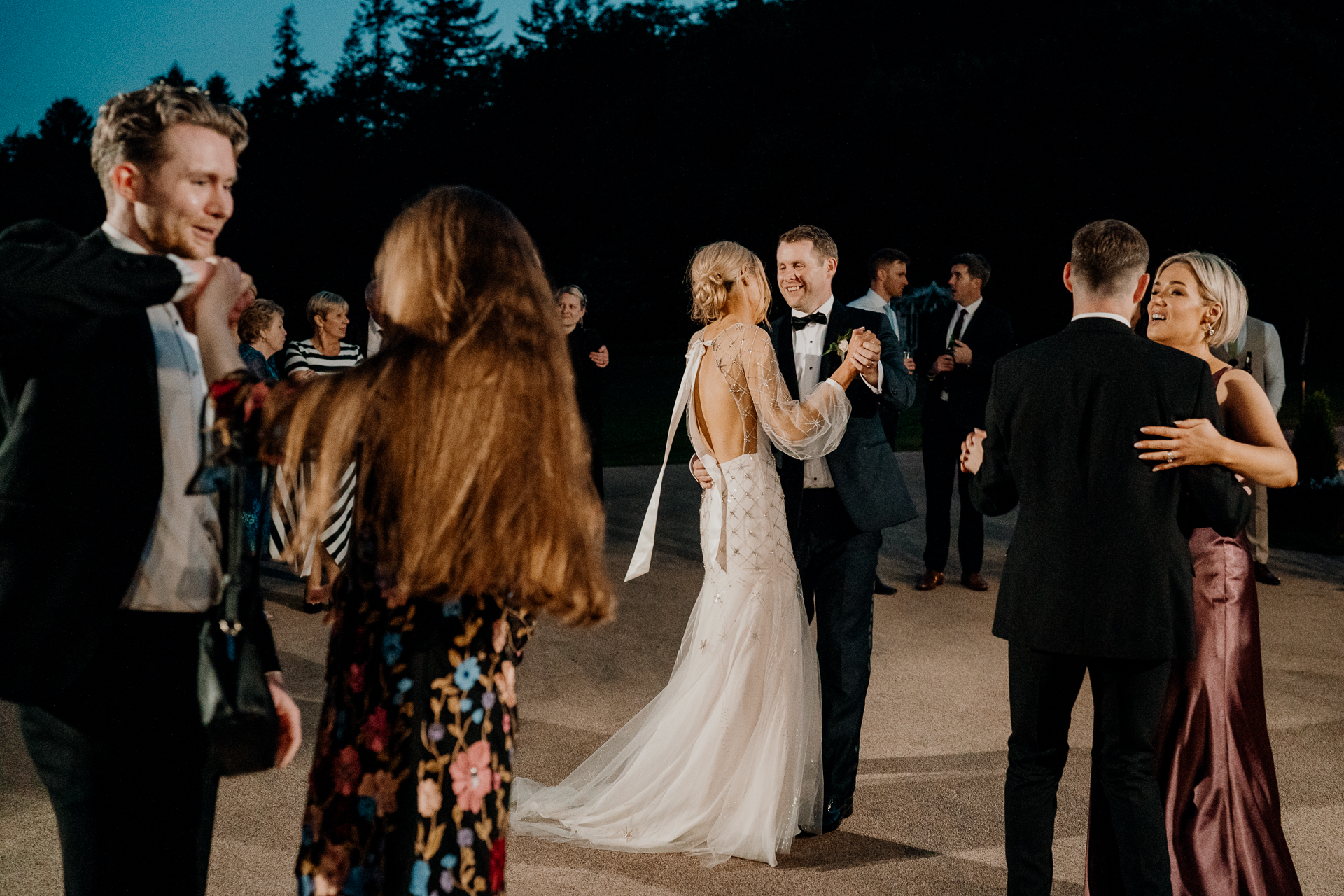 A woman in a white dress and a man in a suit and a woman in a white dress