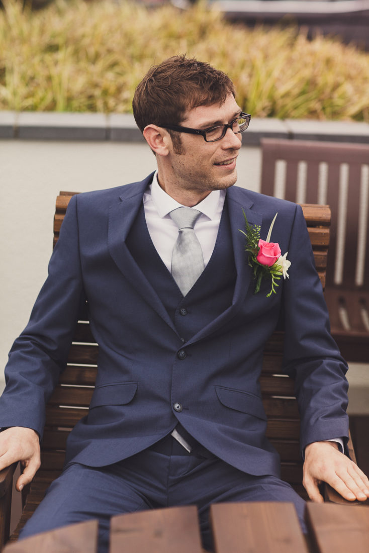 A man wearing a suit and tie sitting on a bench