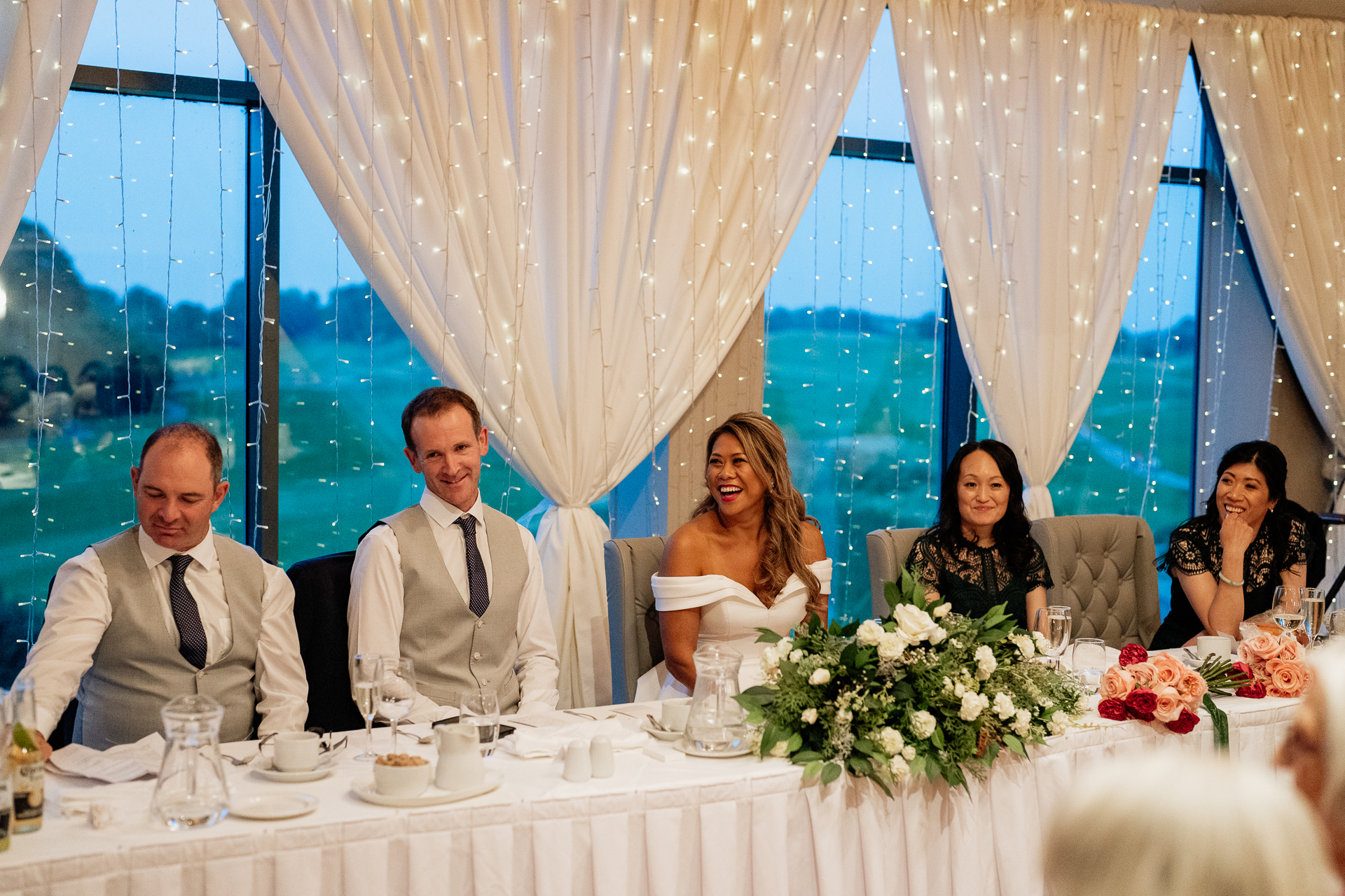 A group of people sitting at a table with flowers