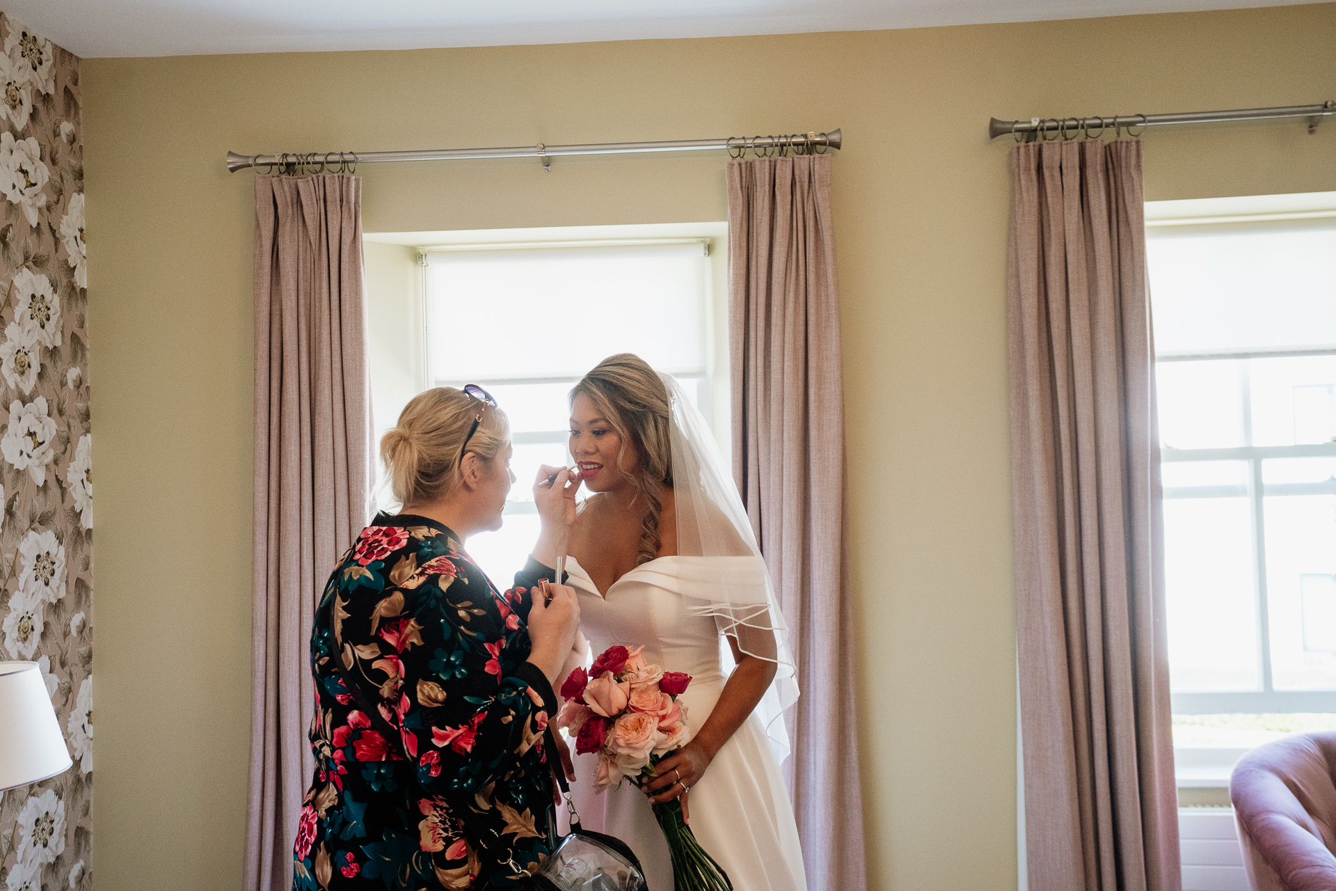 A person in a white dress holding a bouquet of flowers in front of a mirror