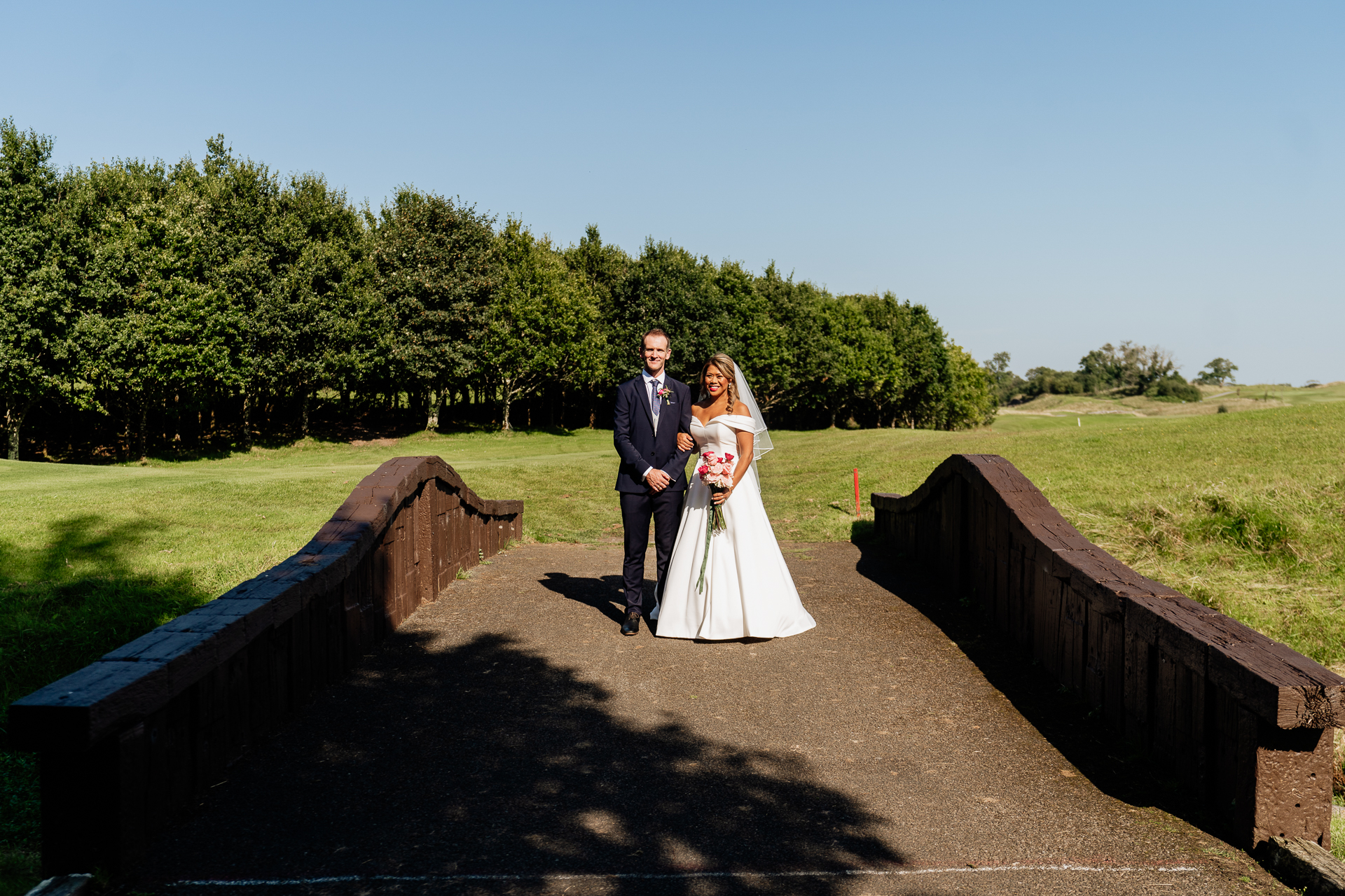 A man and woman posing for a picture on a bridge