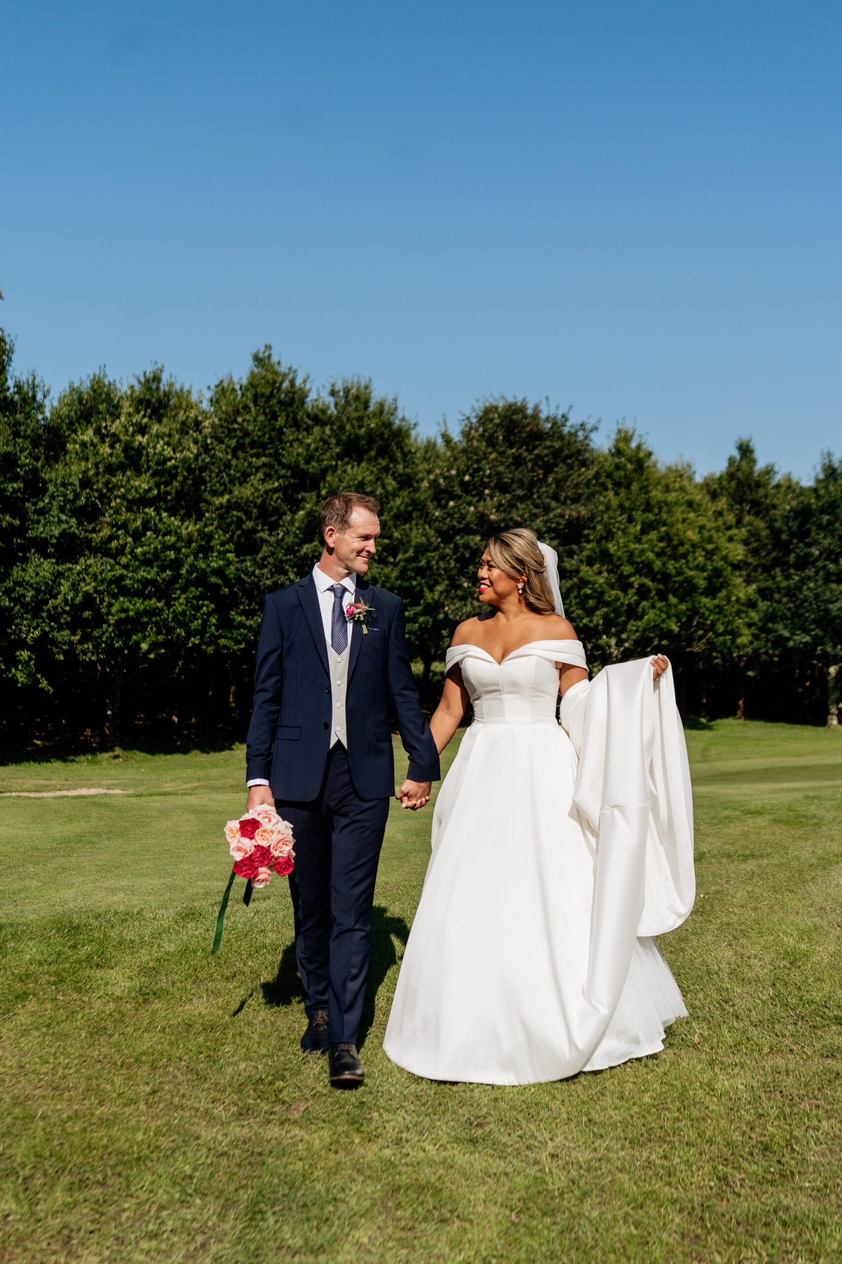 A man and woman walking in a field with flowers