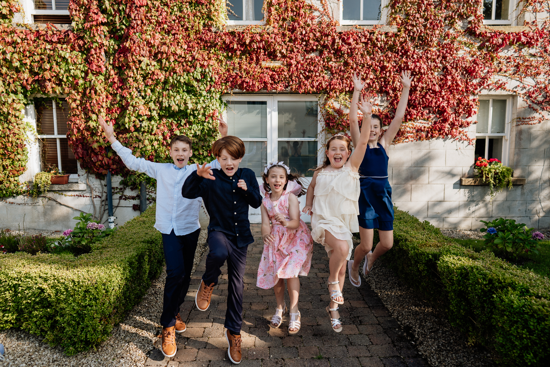 A group of people jumping in the air in front of a house