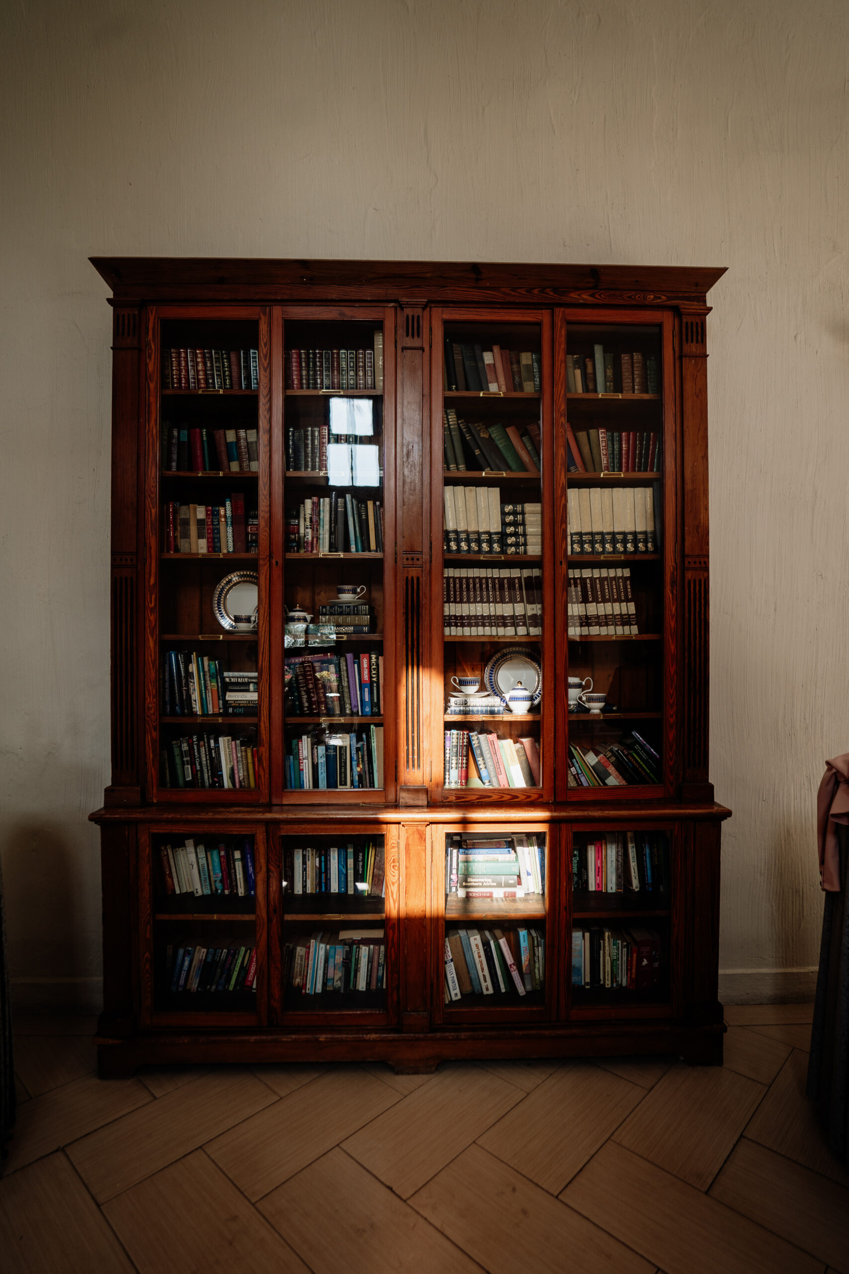 A wooden cabinet with many books