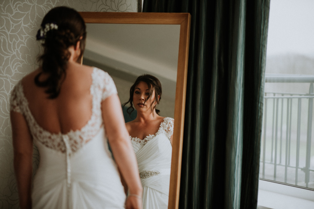 A woman standing in front of a mirror posing for the camera