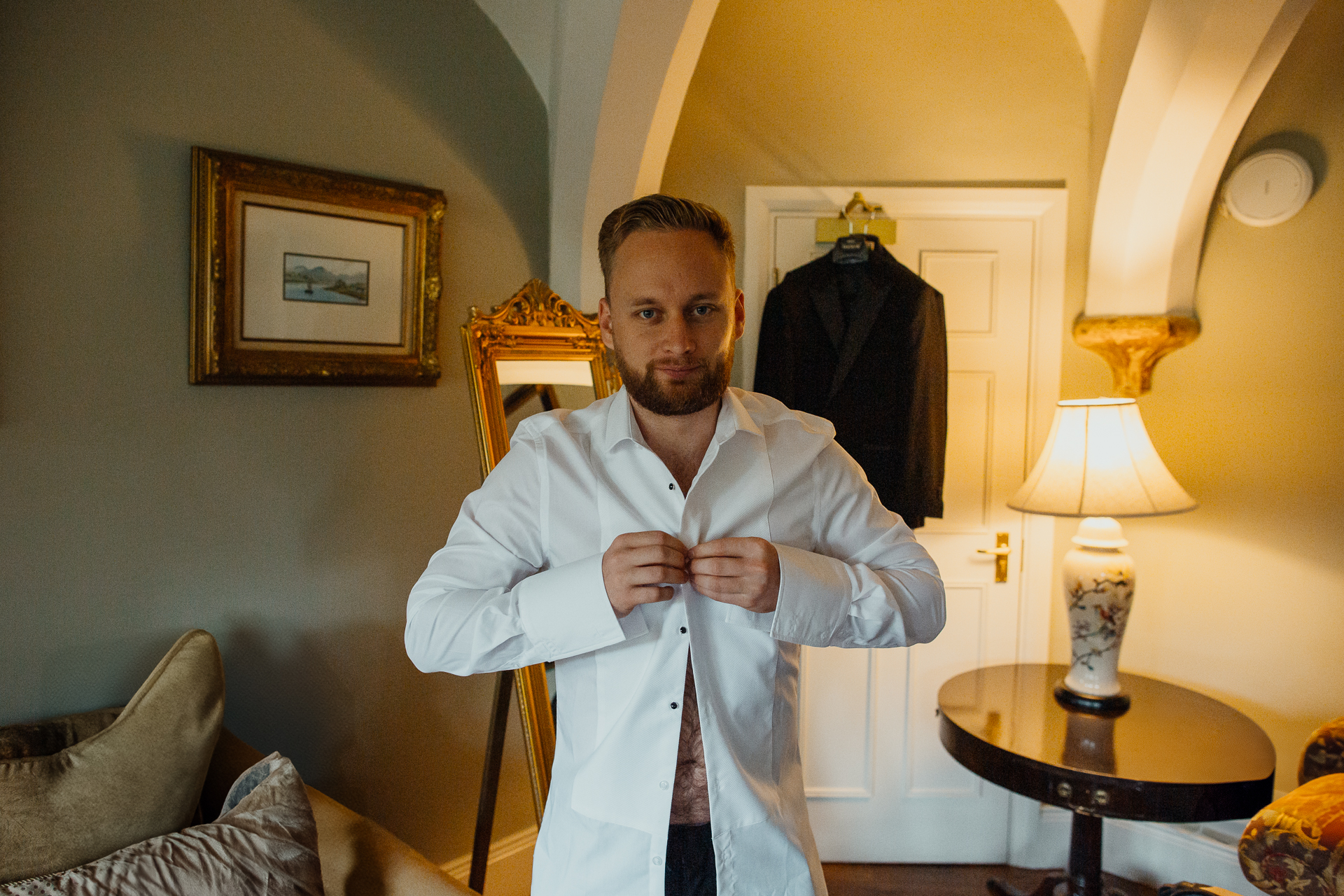 A man in a white robe holds a tie