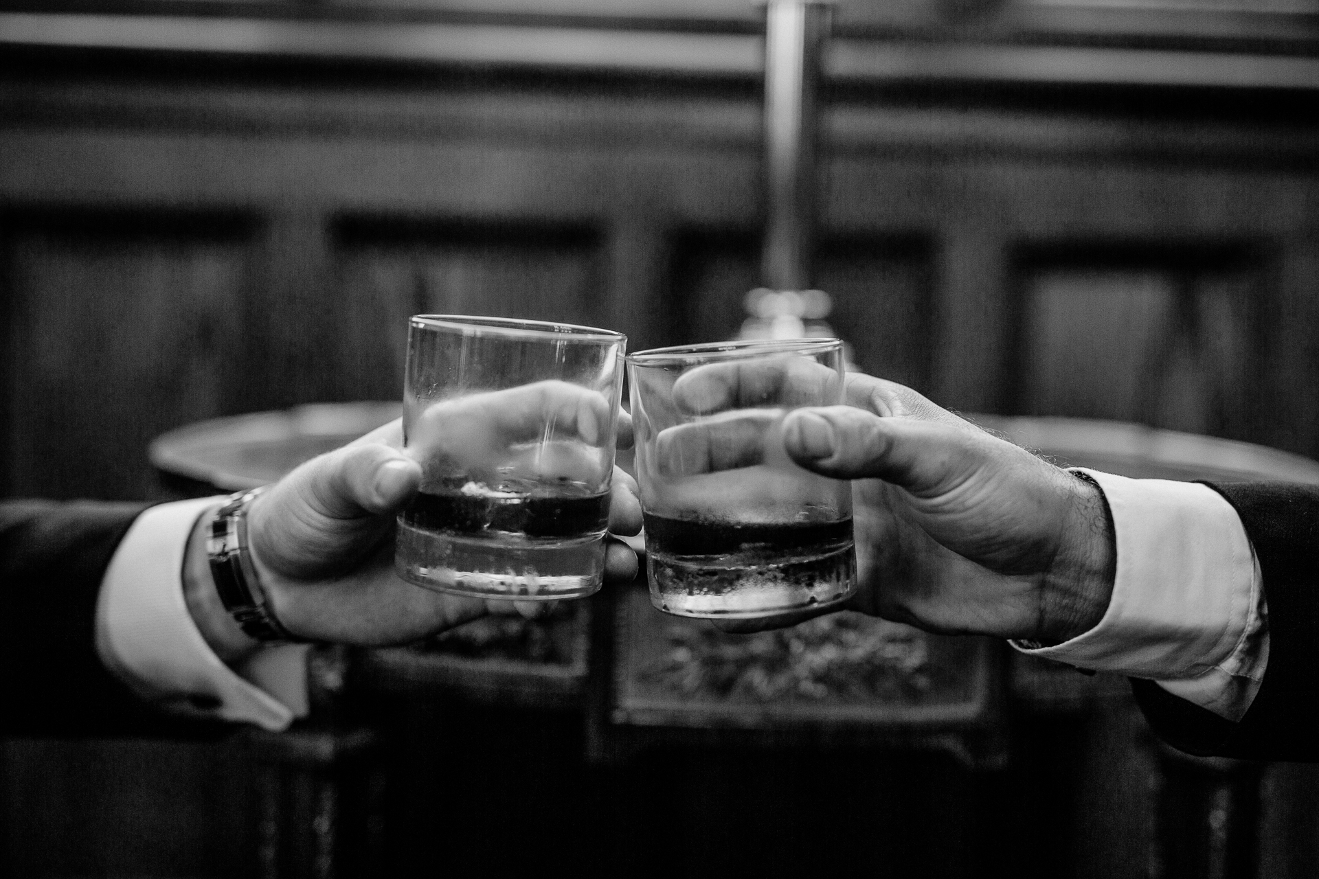 A few hands holding glasses of liquid