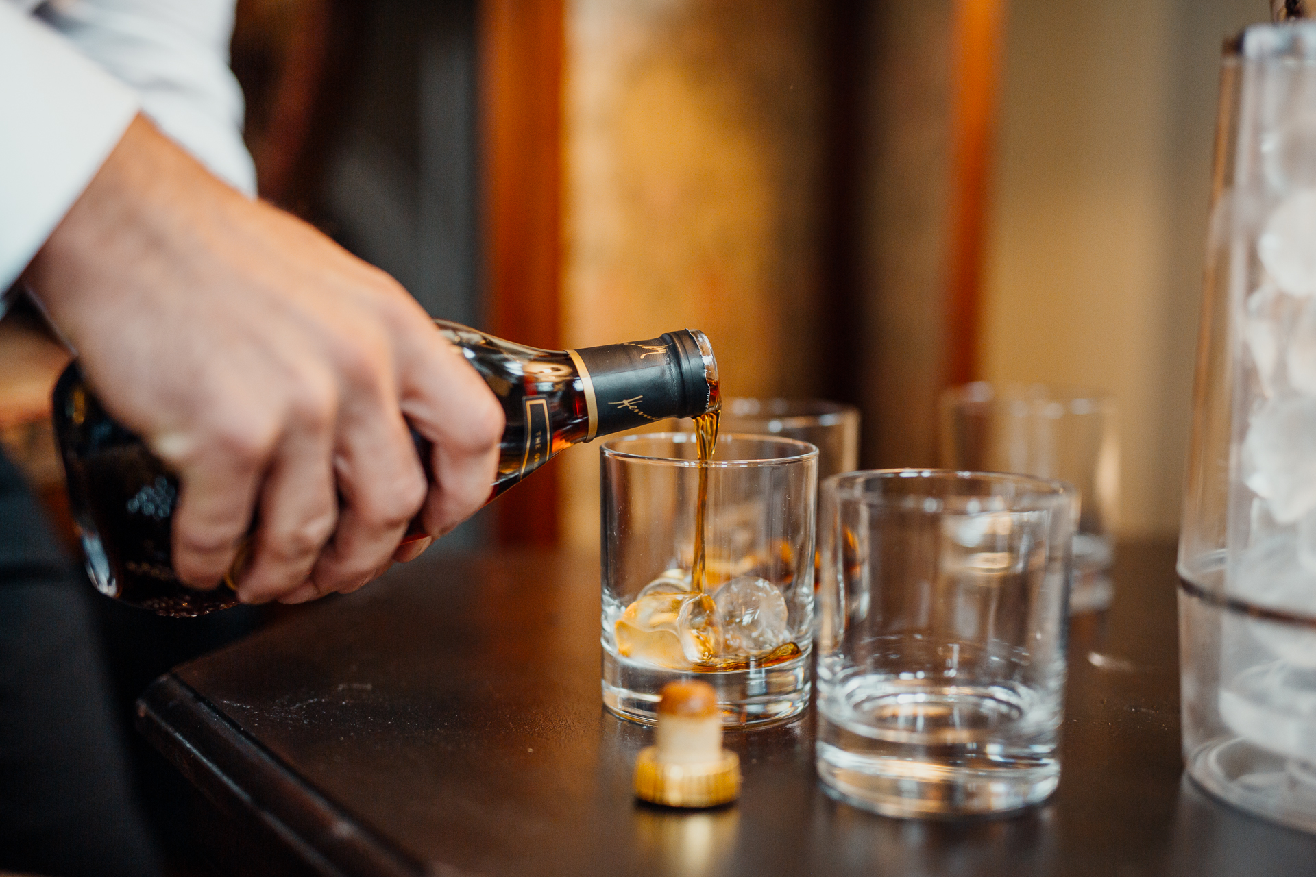 A person pouring liquid into glasses