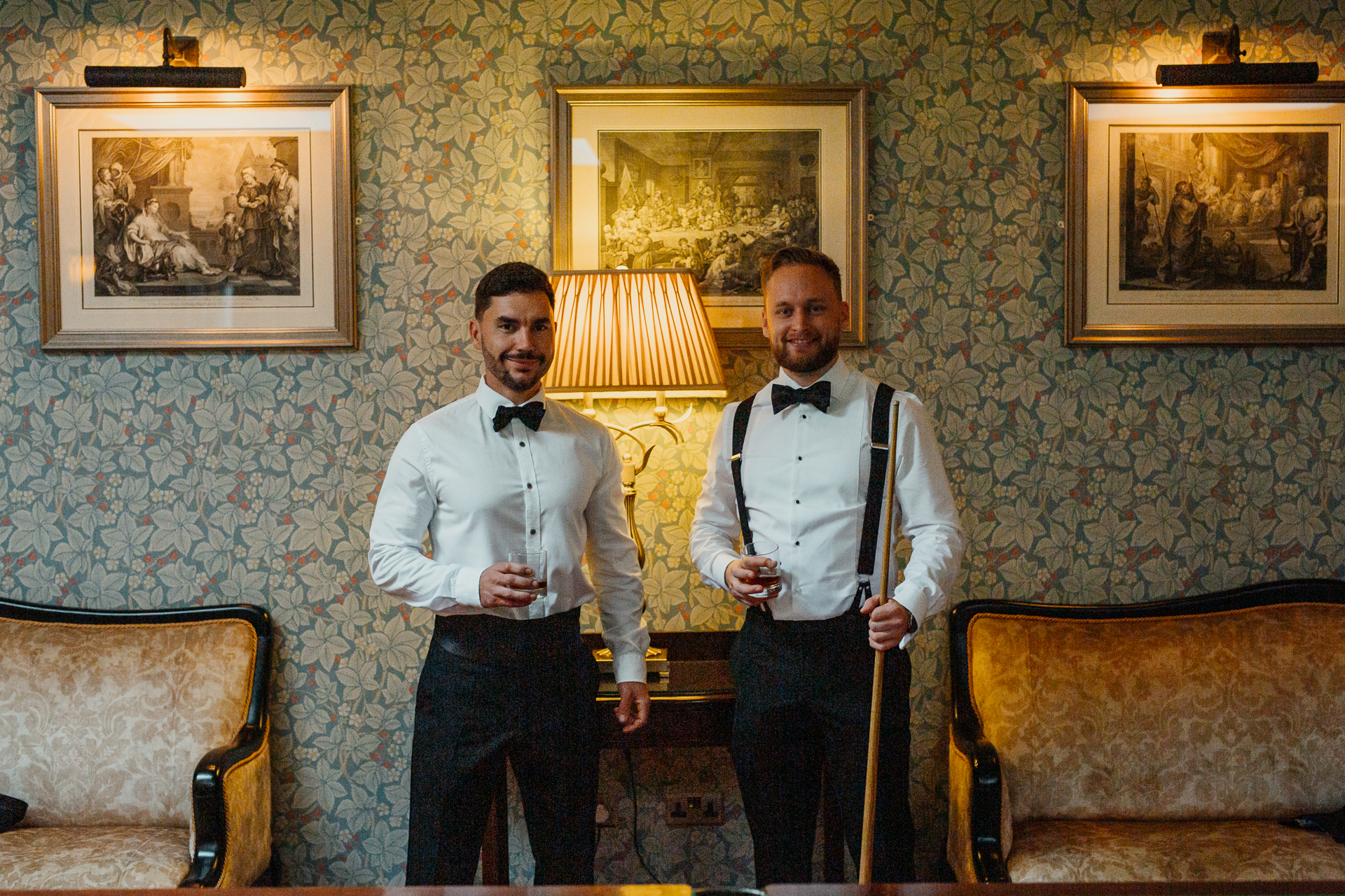 A couple of men in tuxedos holding canes