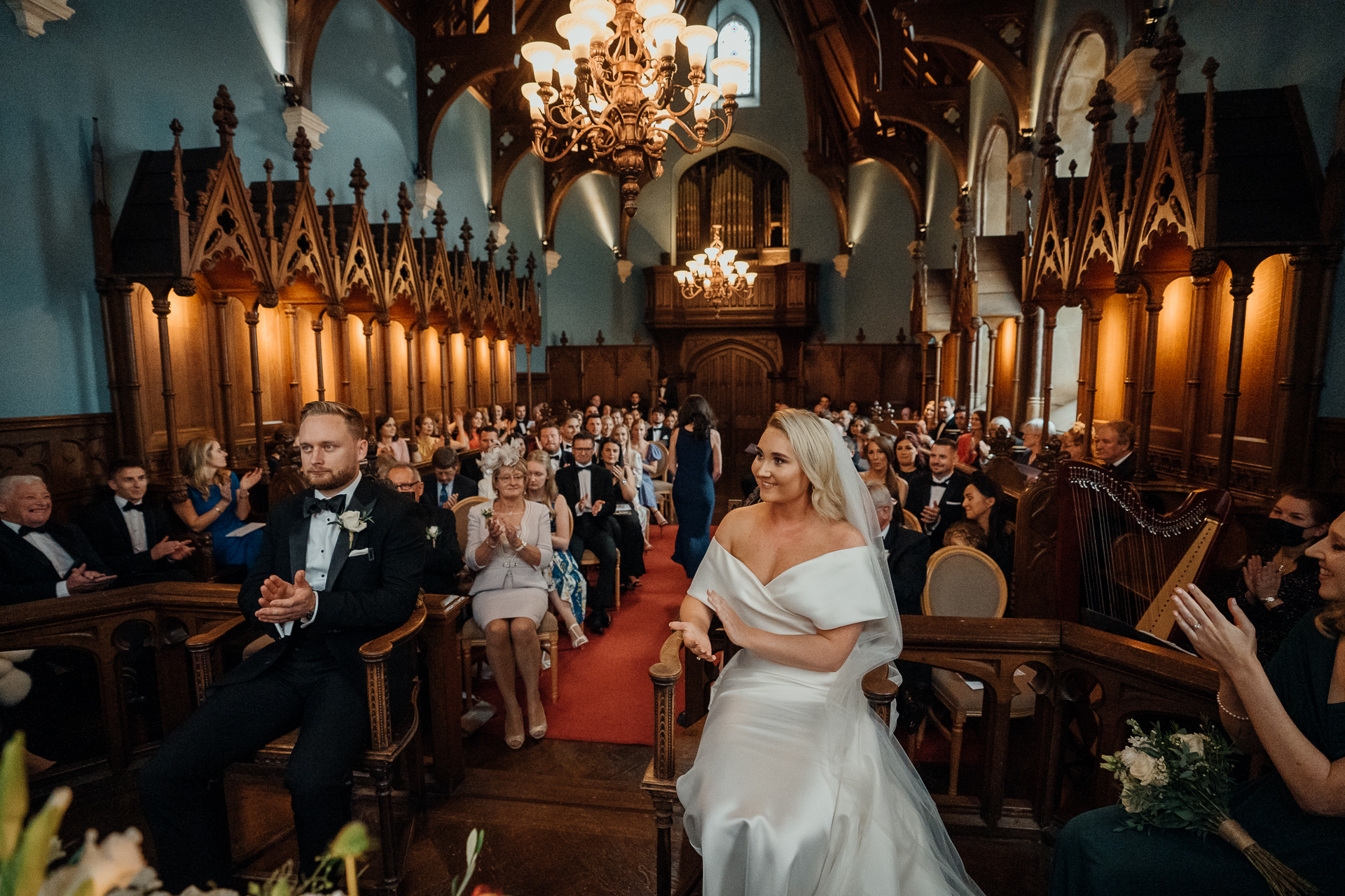 A bride and groom dancing in a fancy room with chandeliers