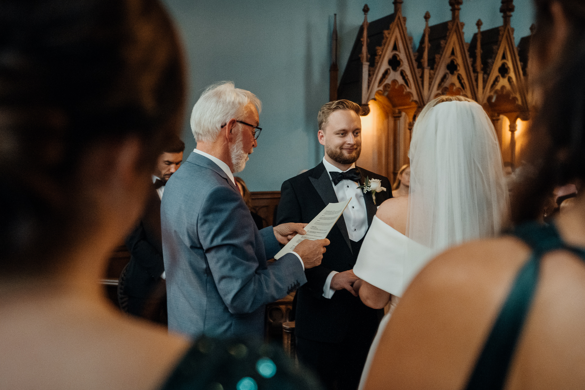 A man in a suit and tie holding a paper in front of a group of people