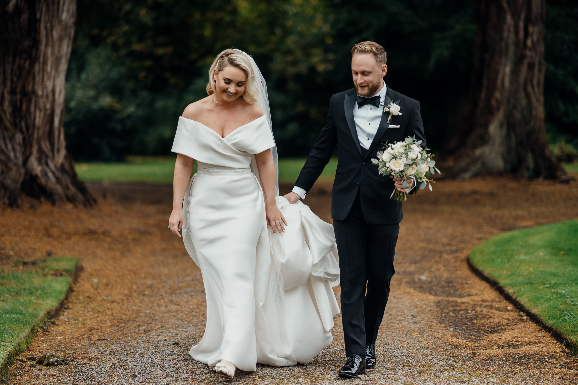 A man and woman walking down a path with flowers