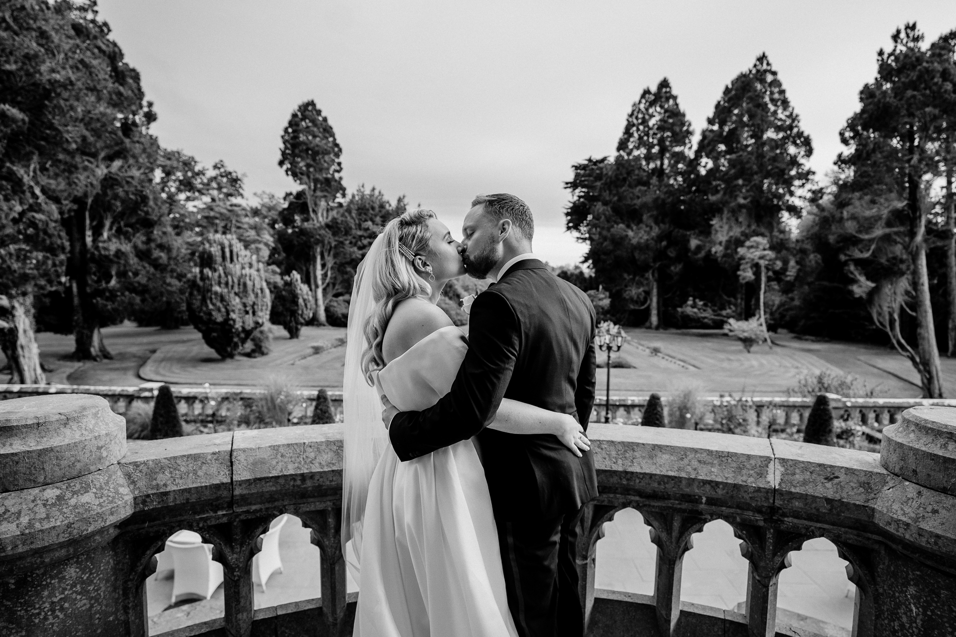 A man and woman kissing on a bridge