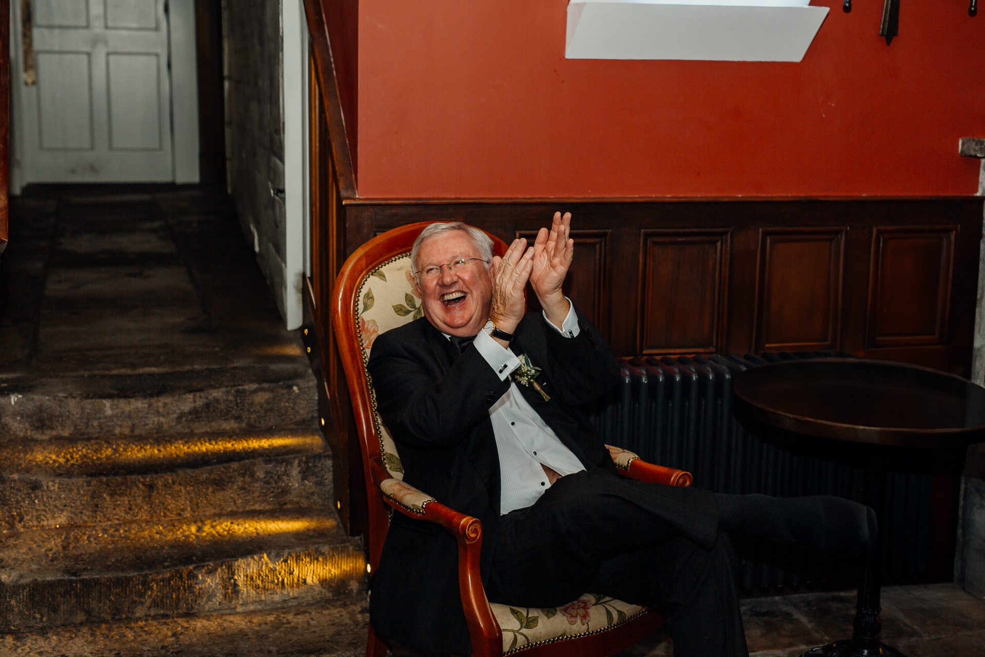 A person in a suit sitting on a bench with the hands up