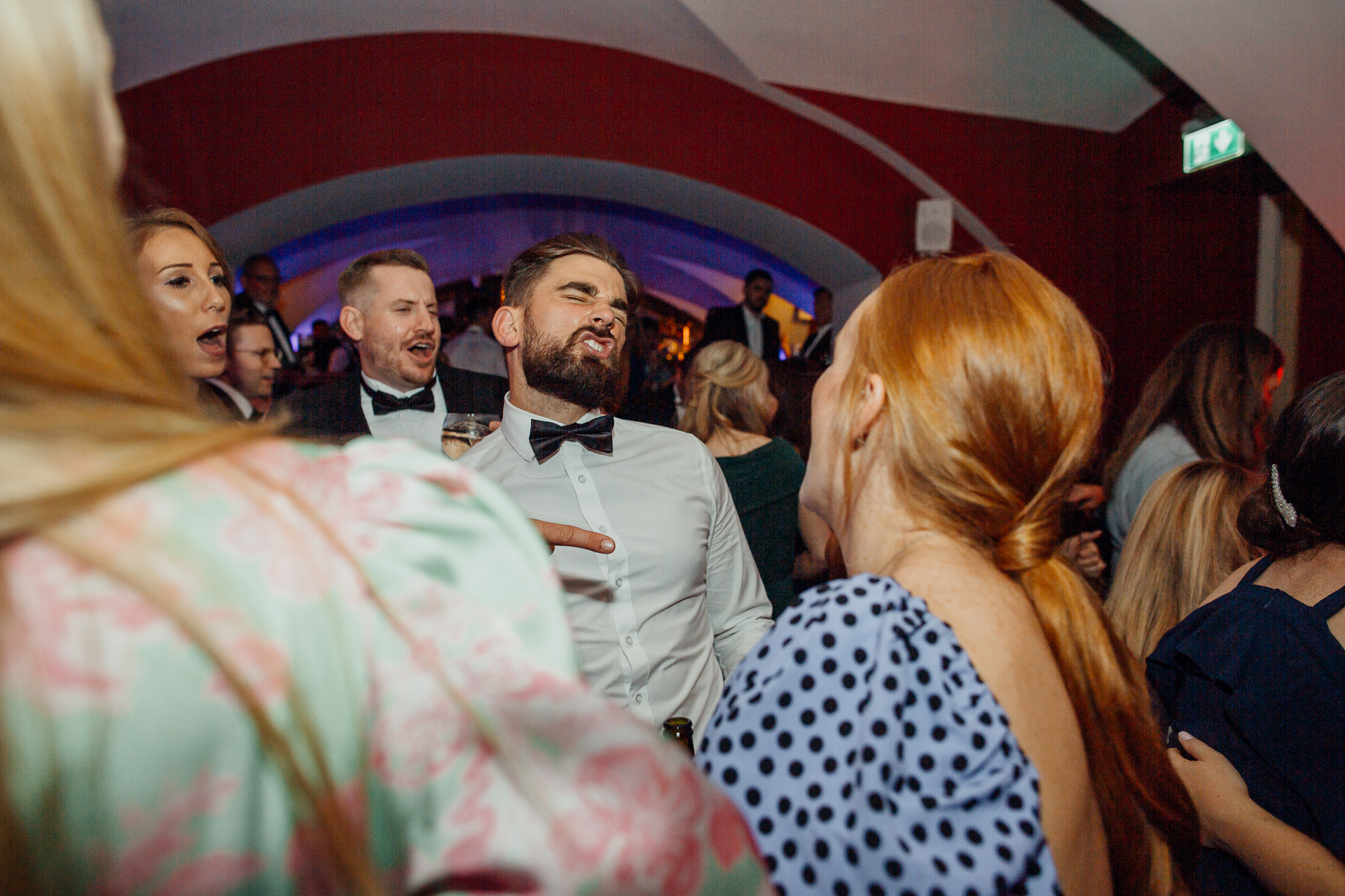 A person in a tuxedo standing in front of a crowd