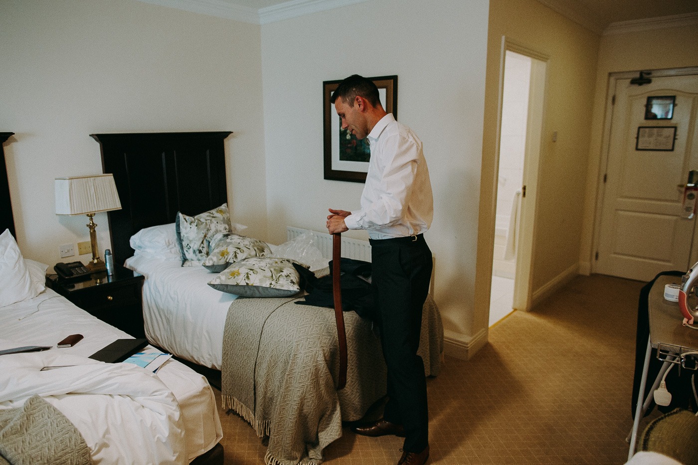 A bedroom with a bed and a man standing in a room