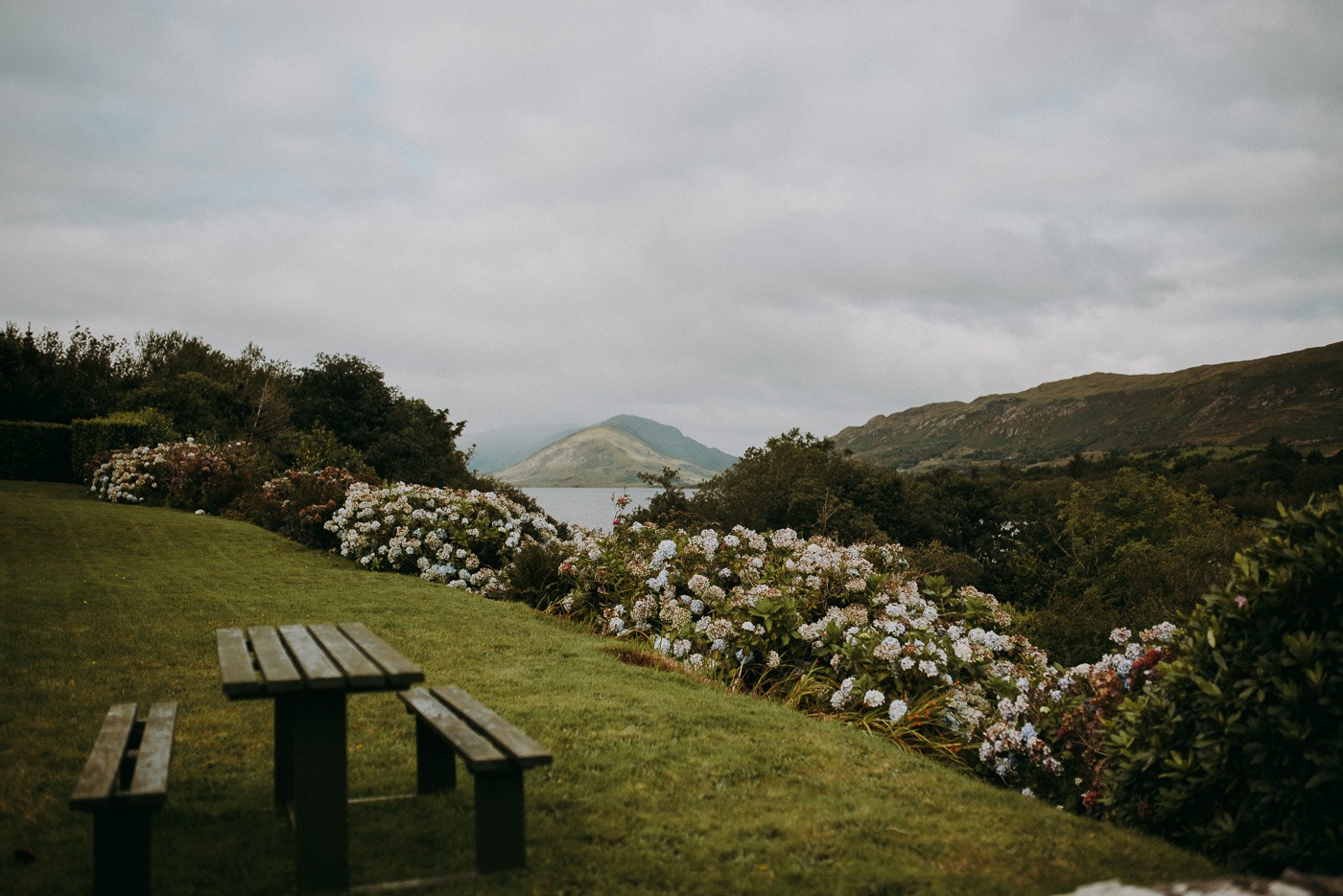 A wooden bench sitting on top of a grass covered field