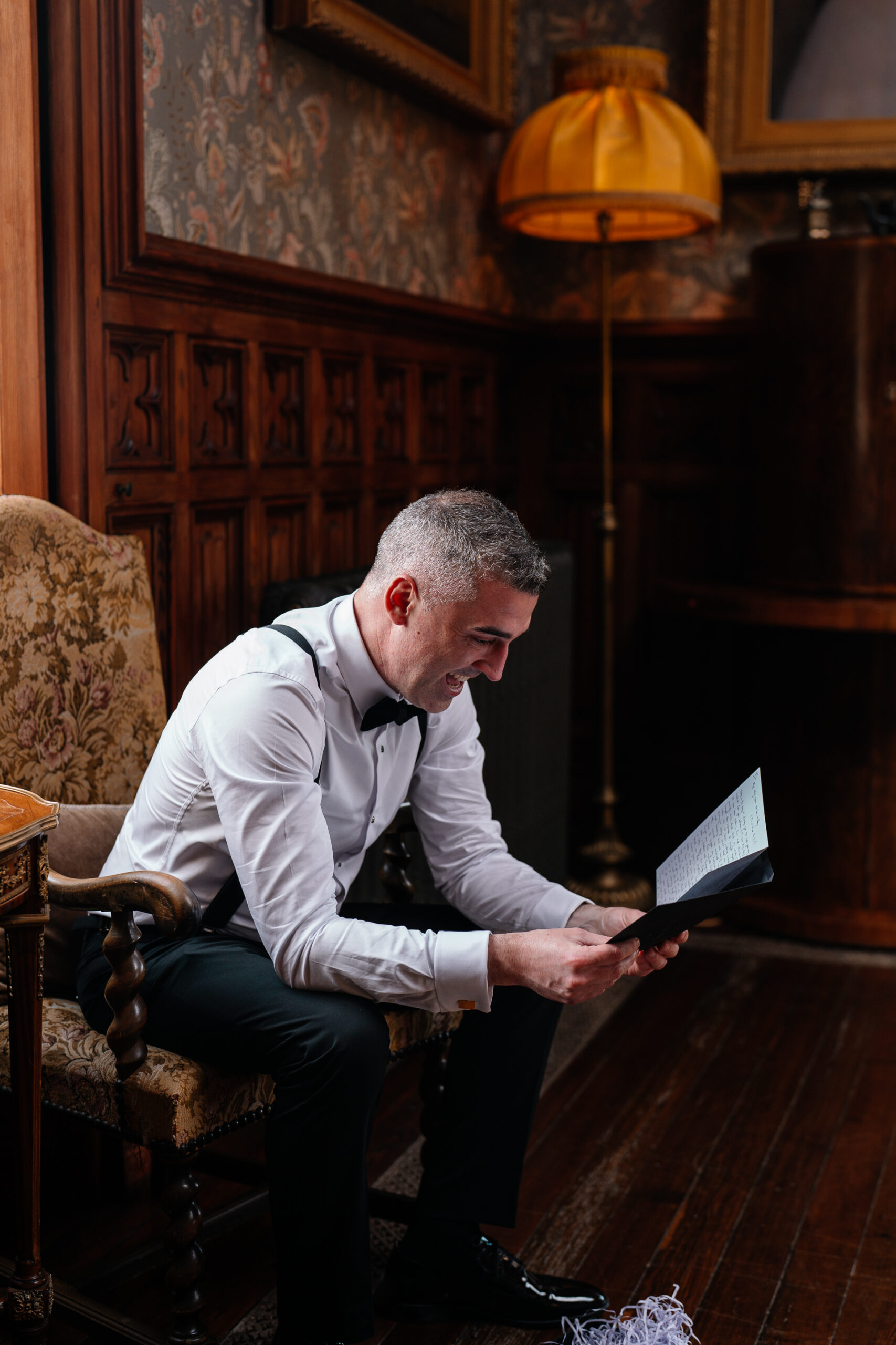 Groom adjusting his bow tie during wedding prep in Billiard Room at Markree Castle