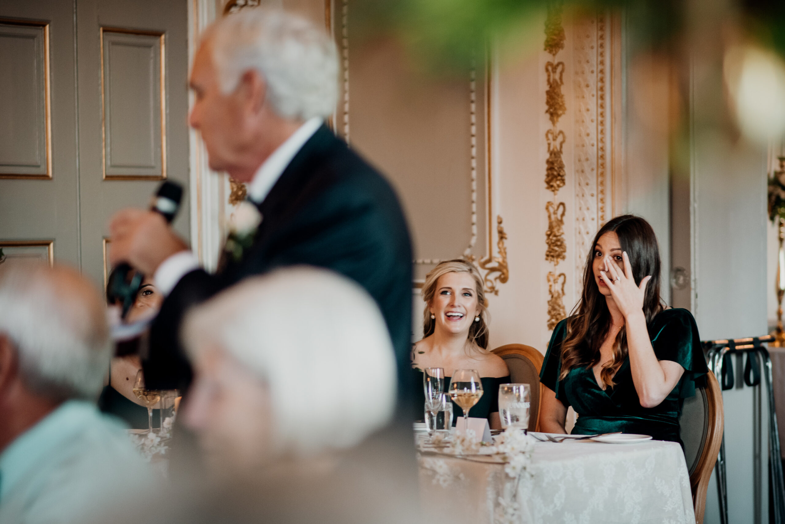 A person talking to a group of people at a dinner table