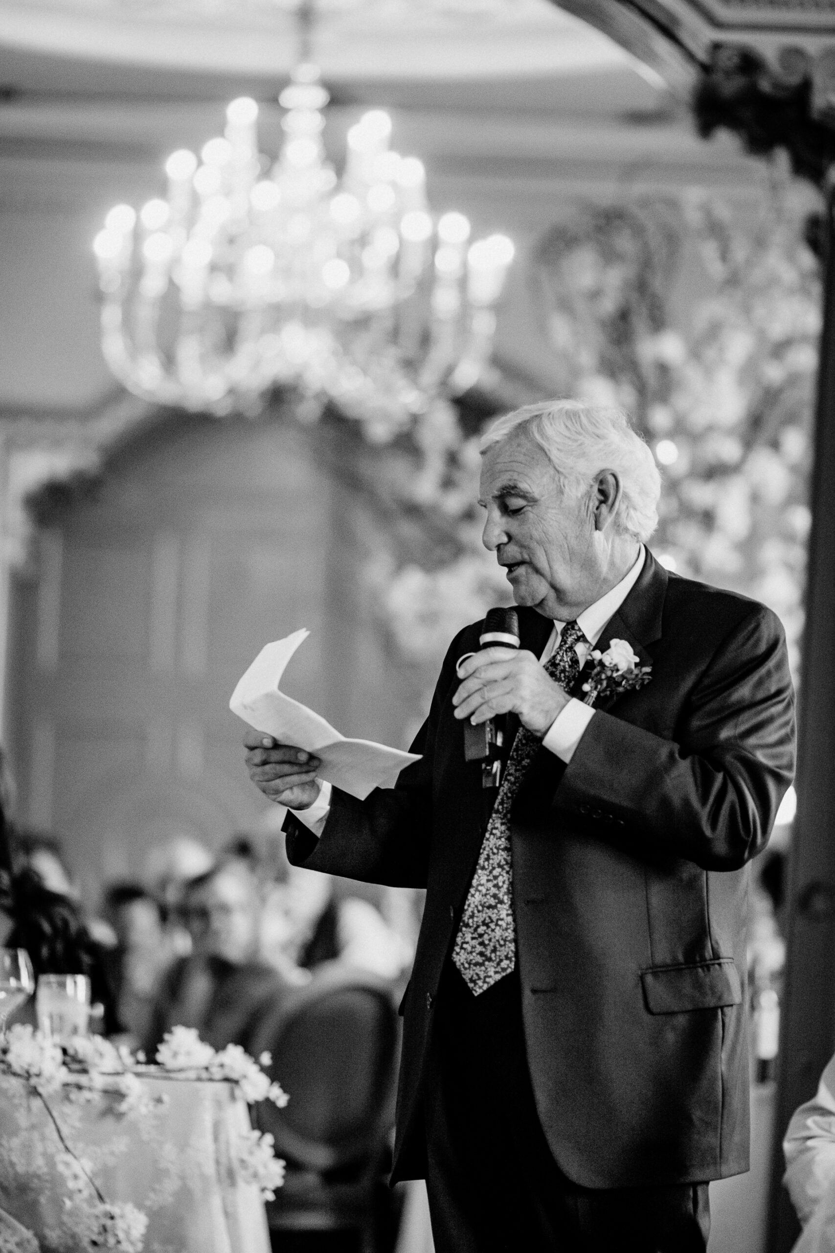 A man holding a paper and a microphone