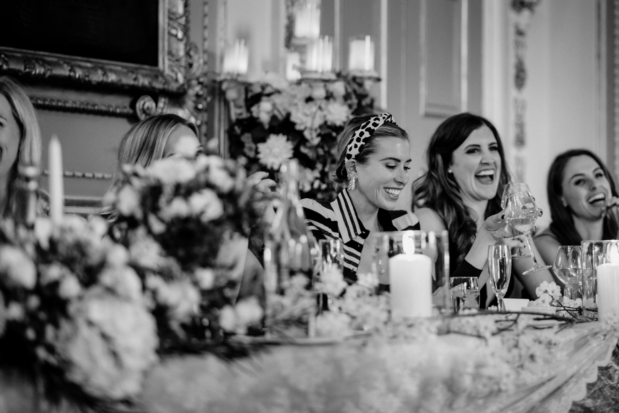 A group of women sitting at a table with flowers