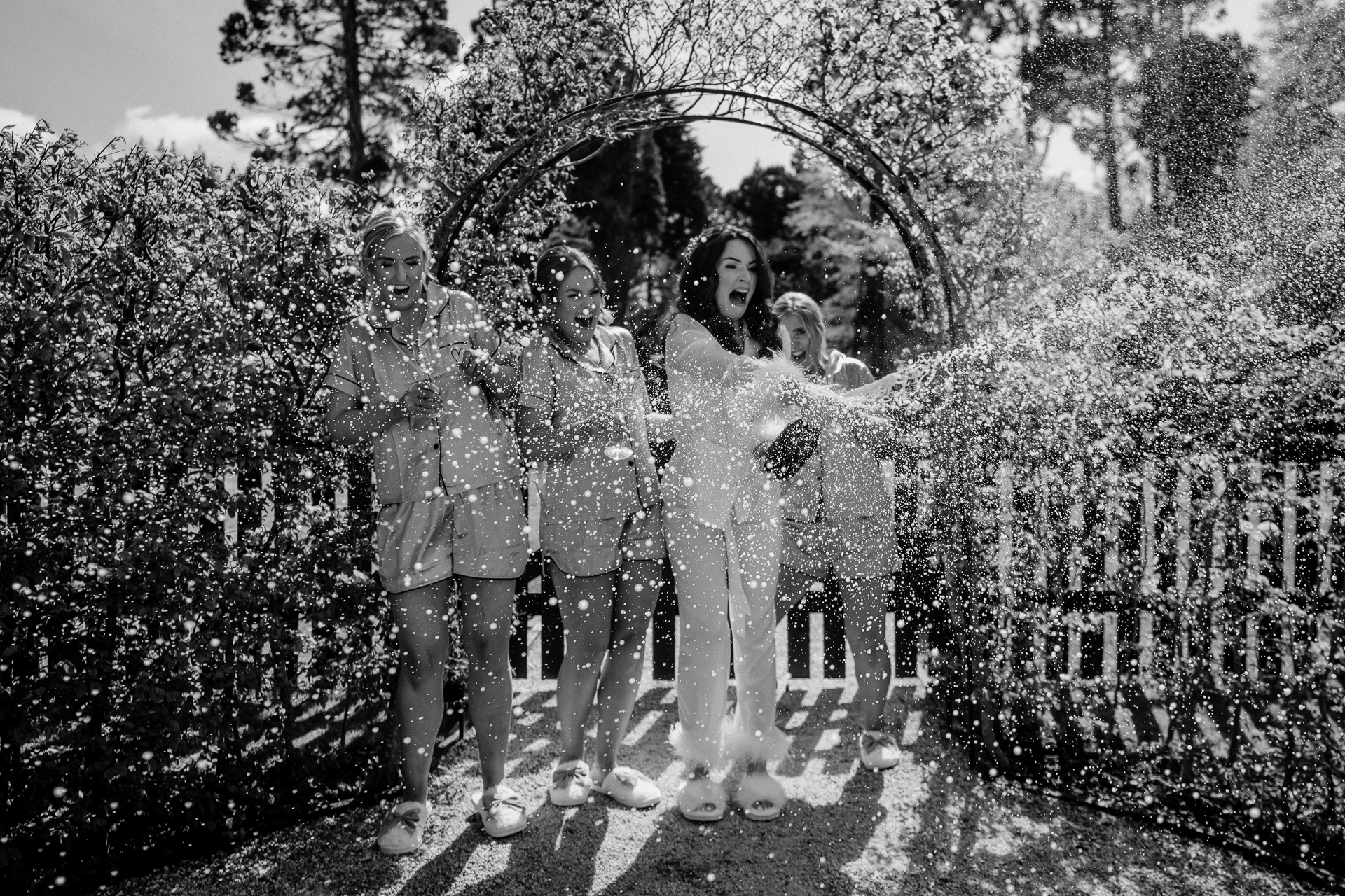 A group of people posing for a photo in front of a large hedge