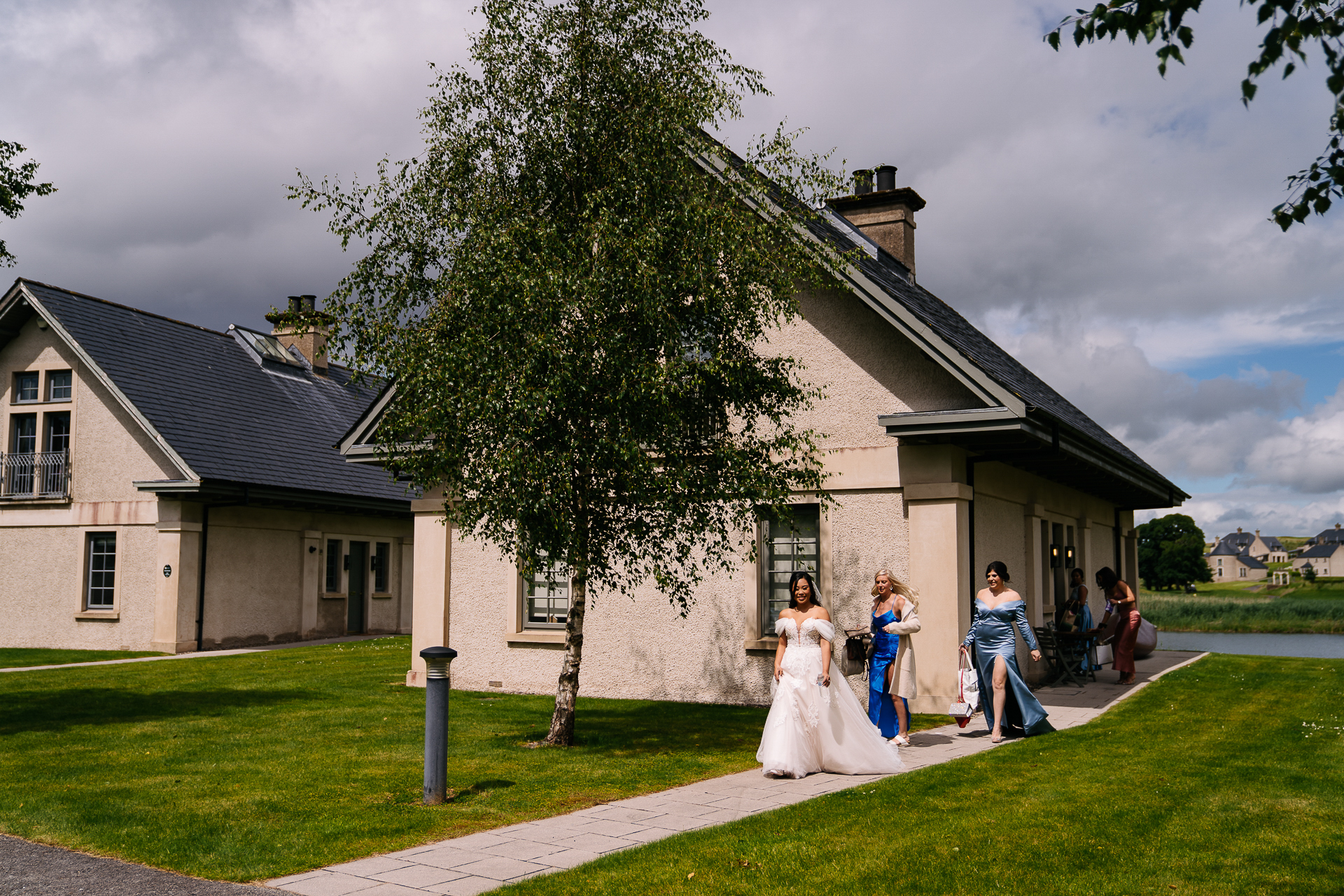 A bride and groom walking down a sidewalk in front of a house