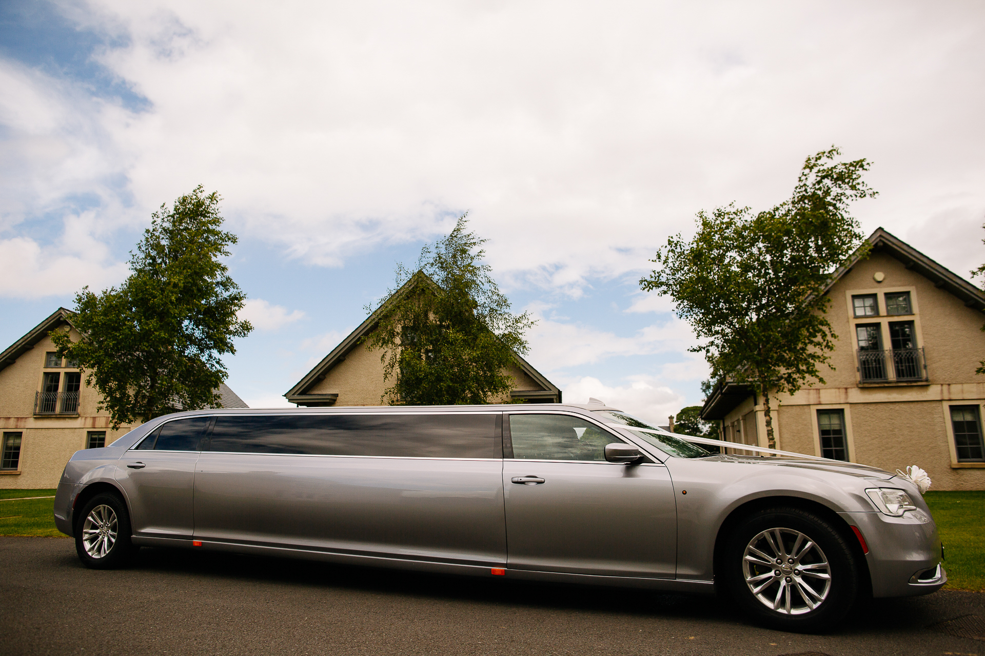 A silver car parked in front of a house