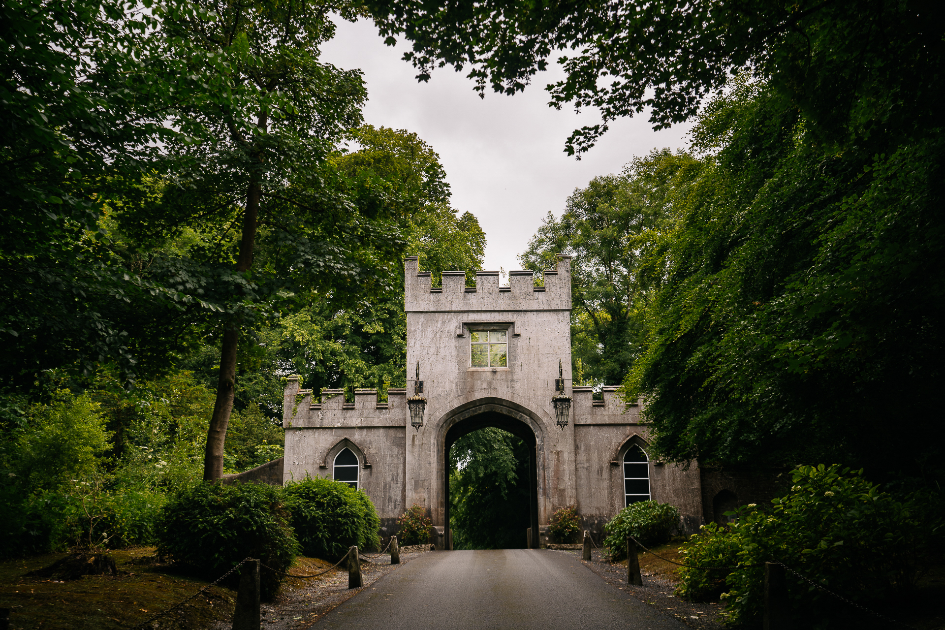 A stone building with a walkway and trees around it