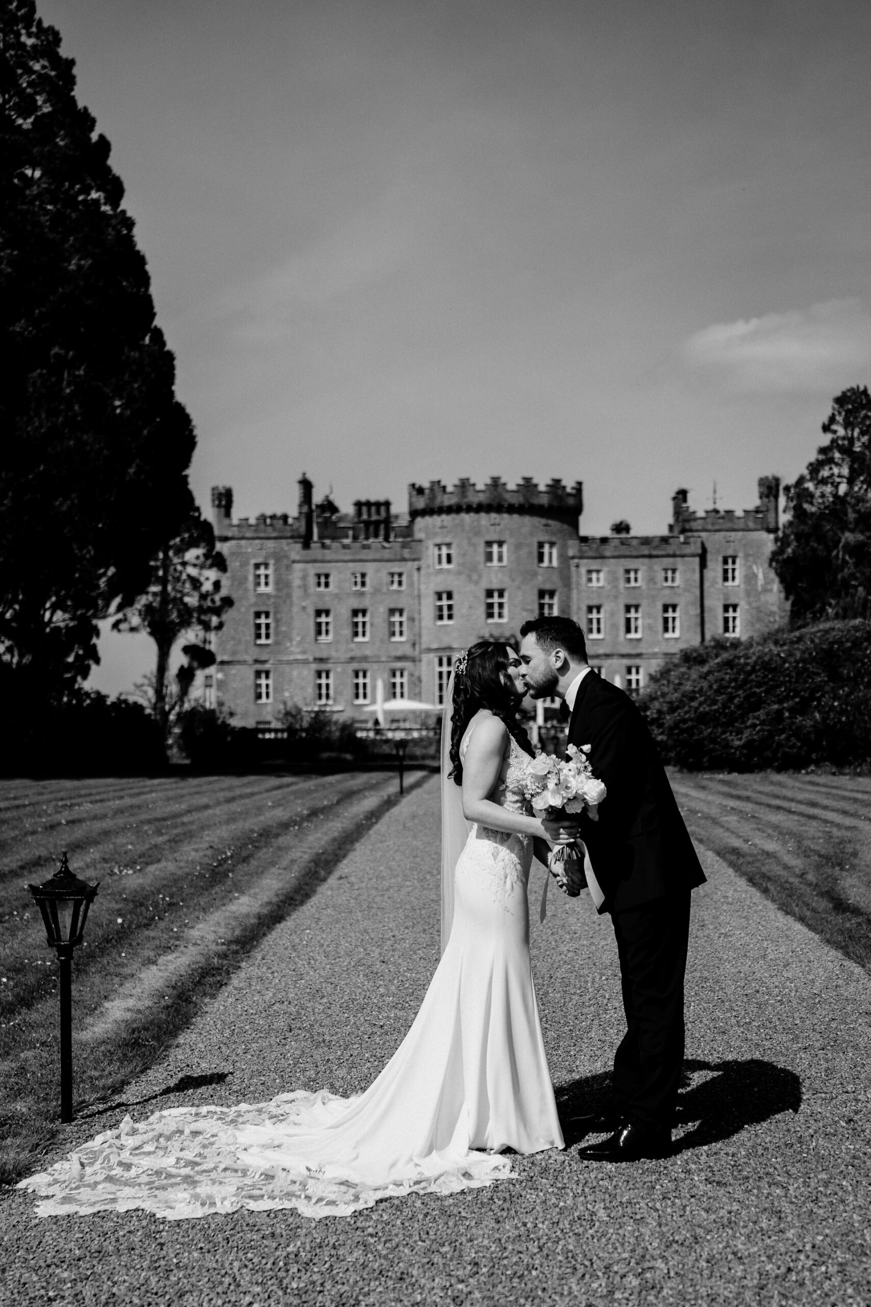 A man and woman kissing in front of a large building