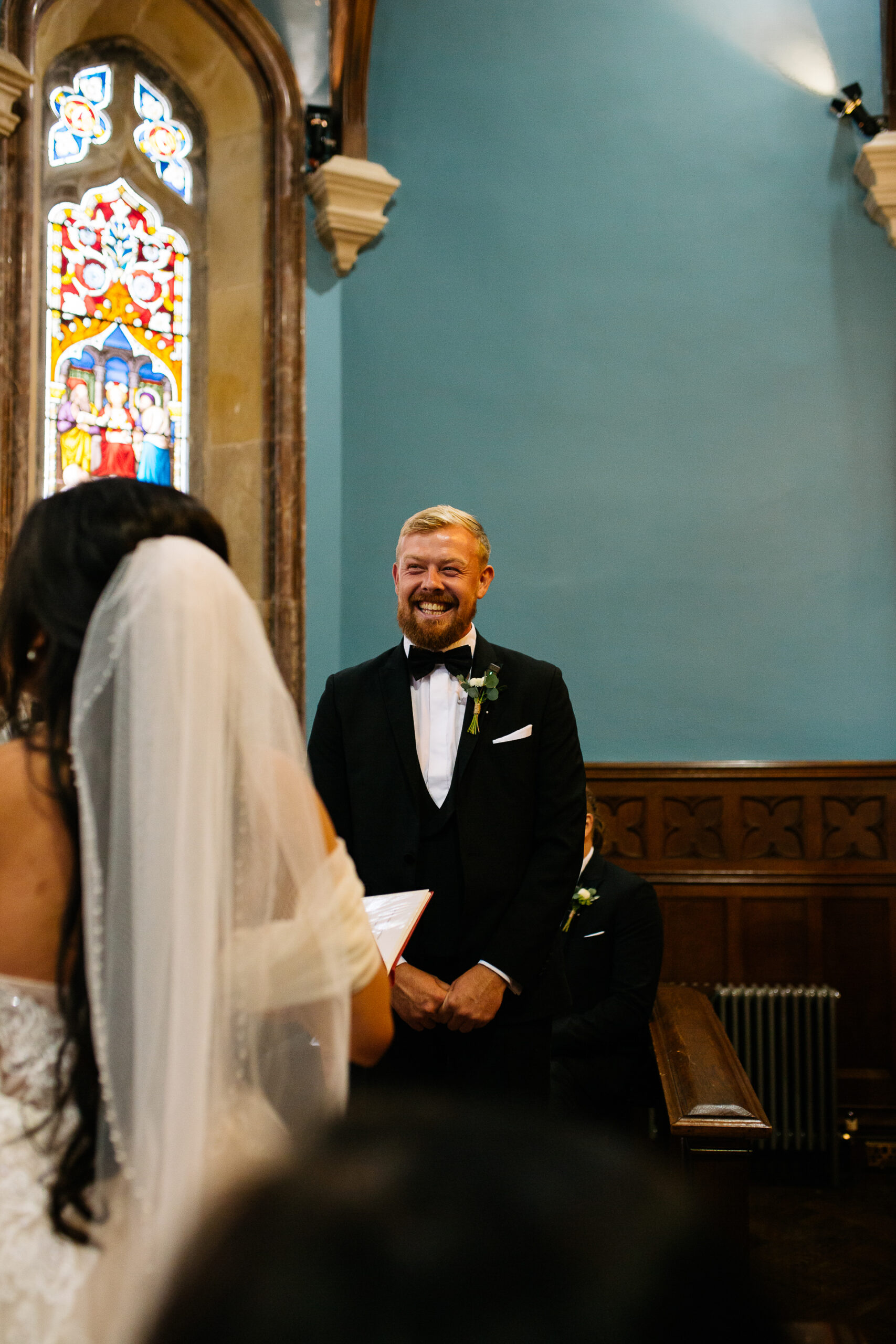 A man in a suit and tie standing in front of a woman in a dress