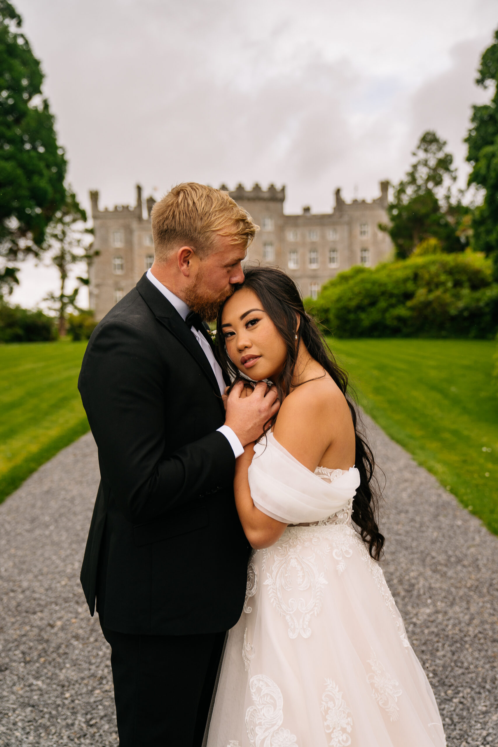 A man and woman posing for a picture in front of a castle