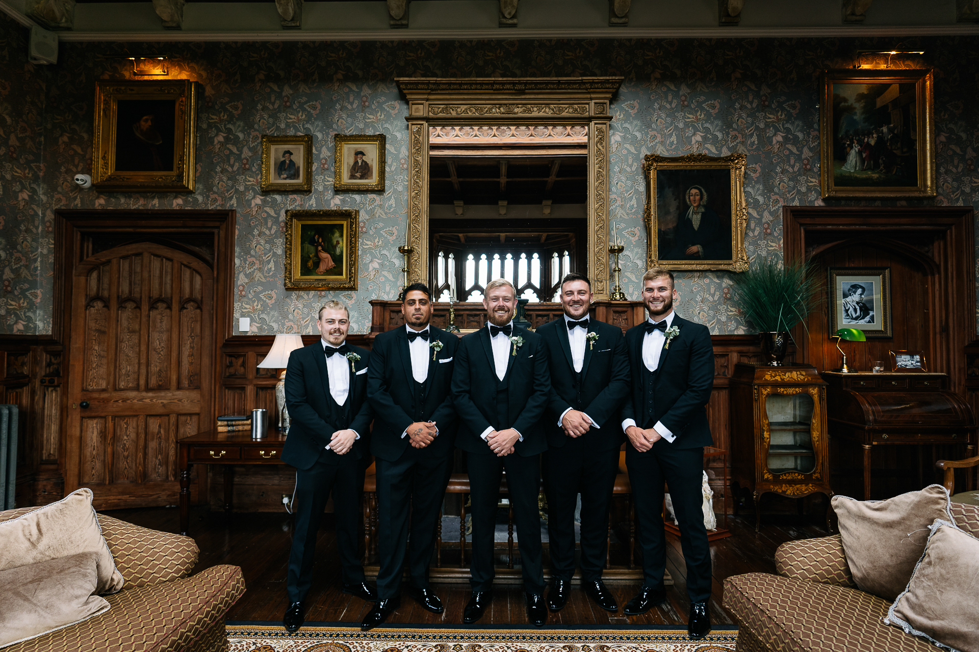 A group of men in suits standing in a room with art on the wall