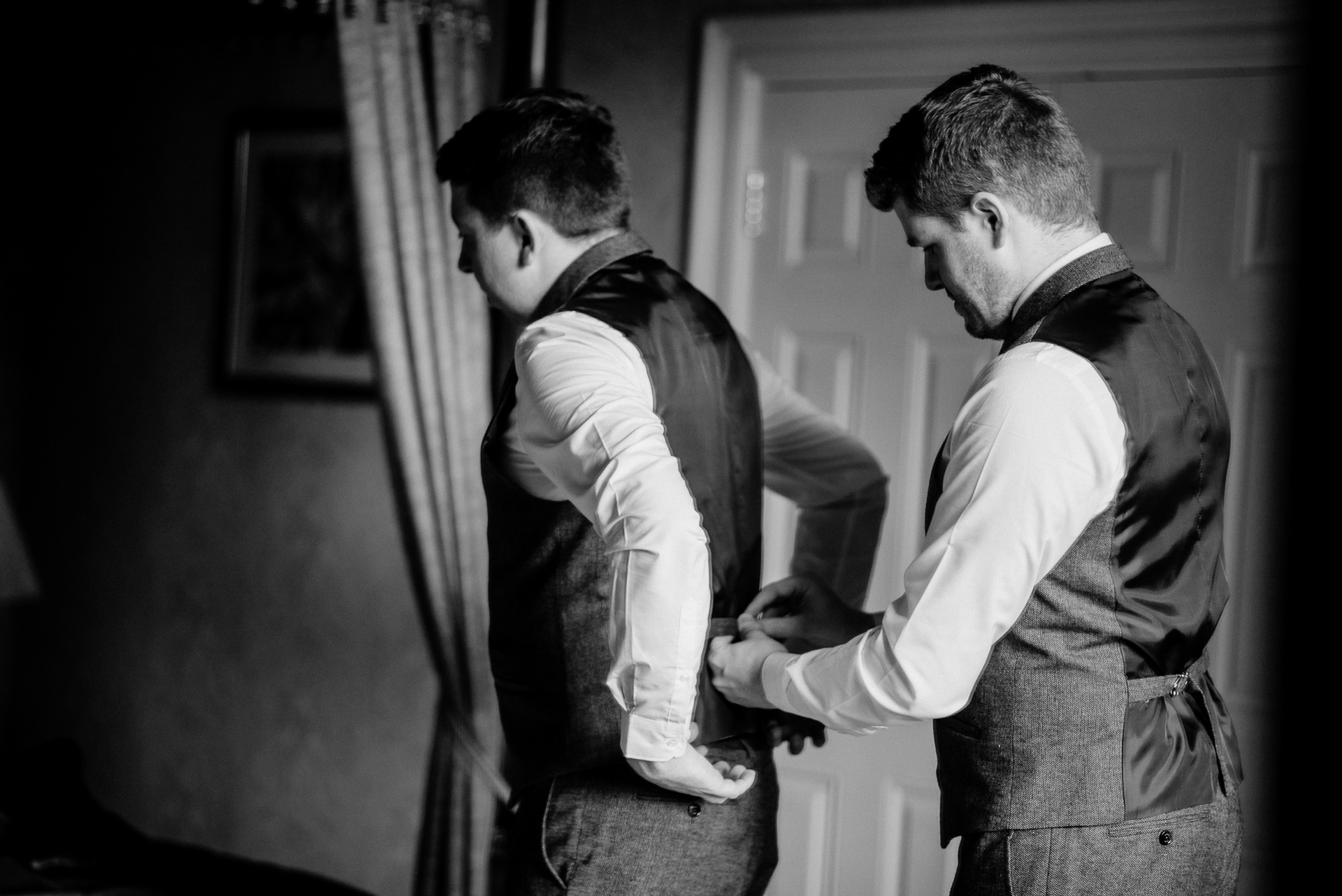 A couple of men looking at a mirror