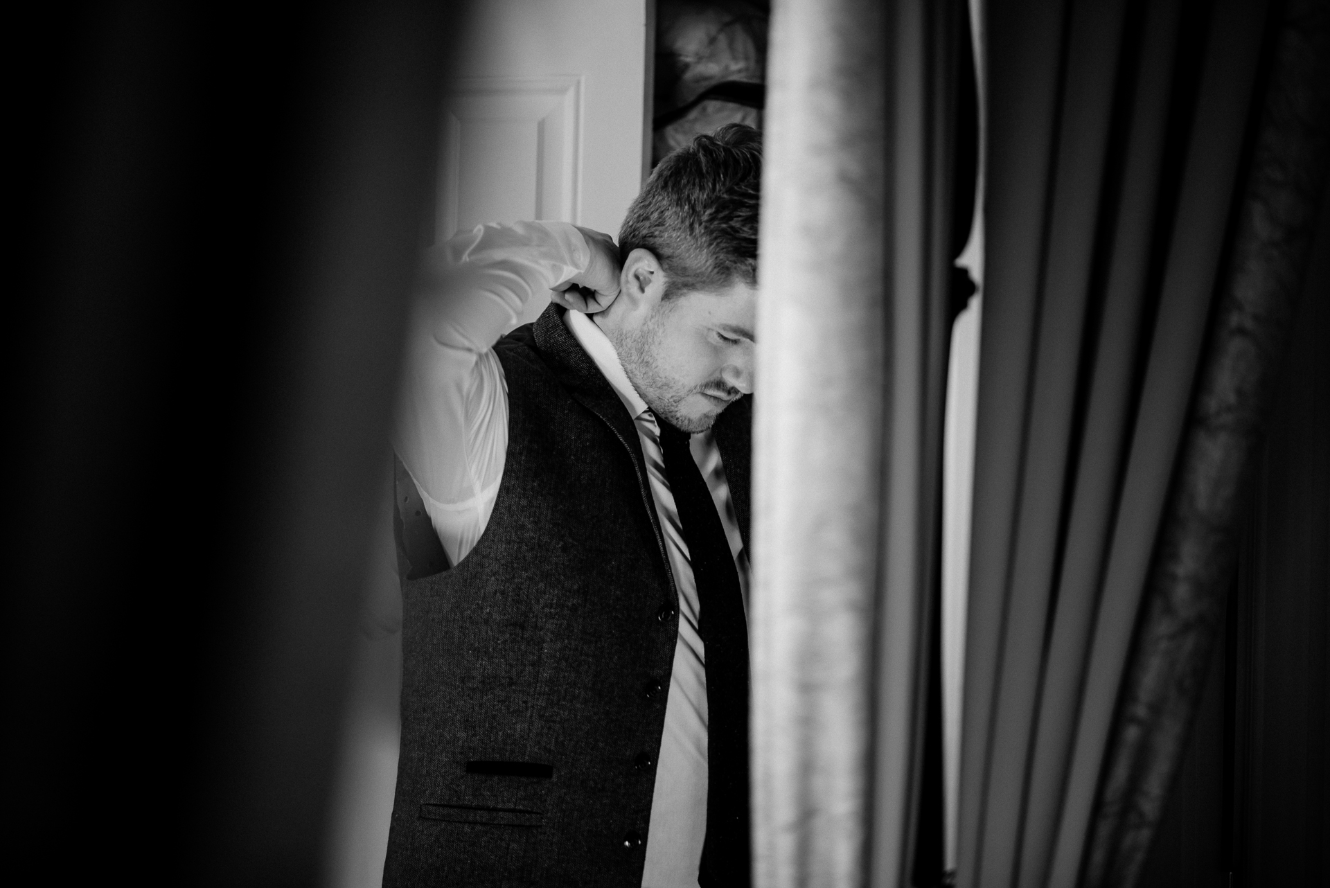 A man in a suit and tie leaning against a wall