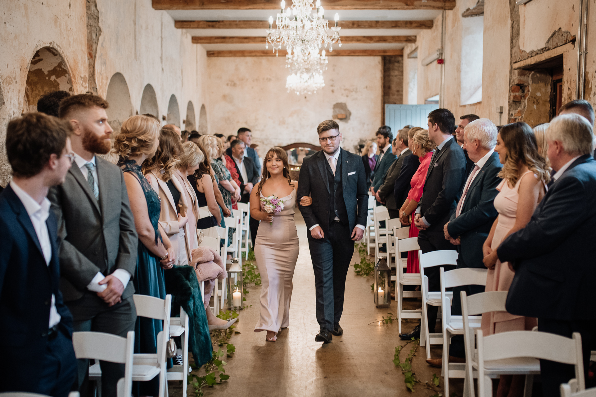 A man and woman walking down a hall with a group of people