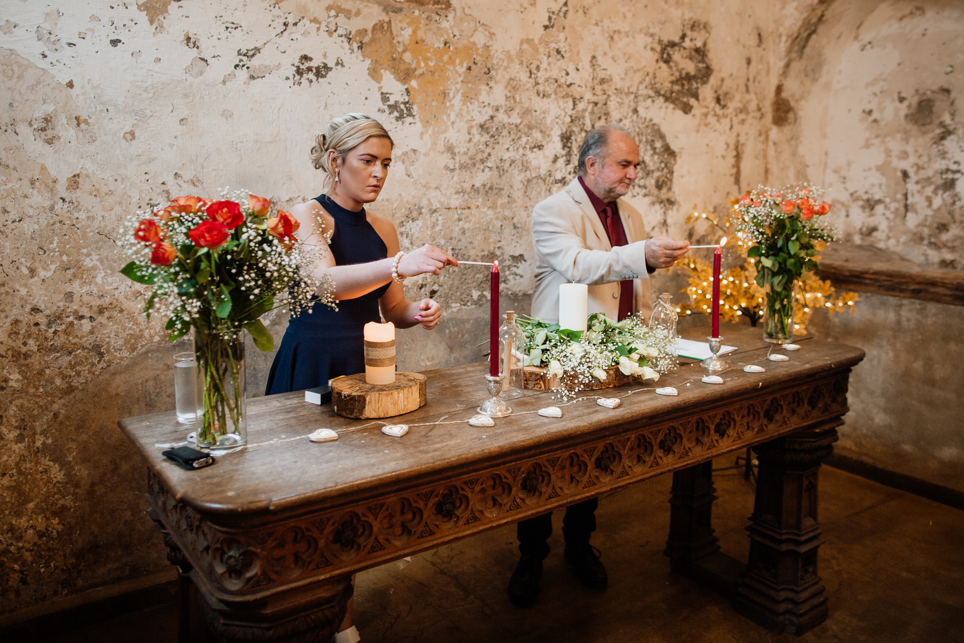 A man and woman sitting at a table with a cake and candles