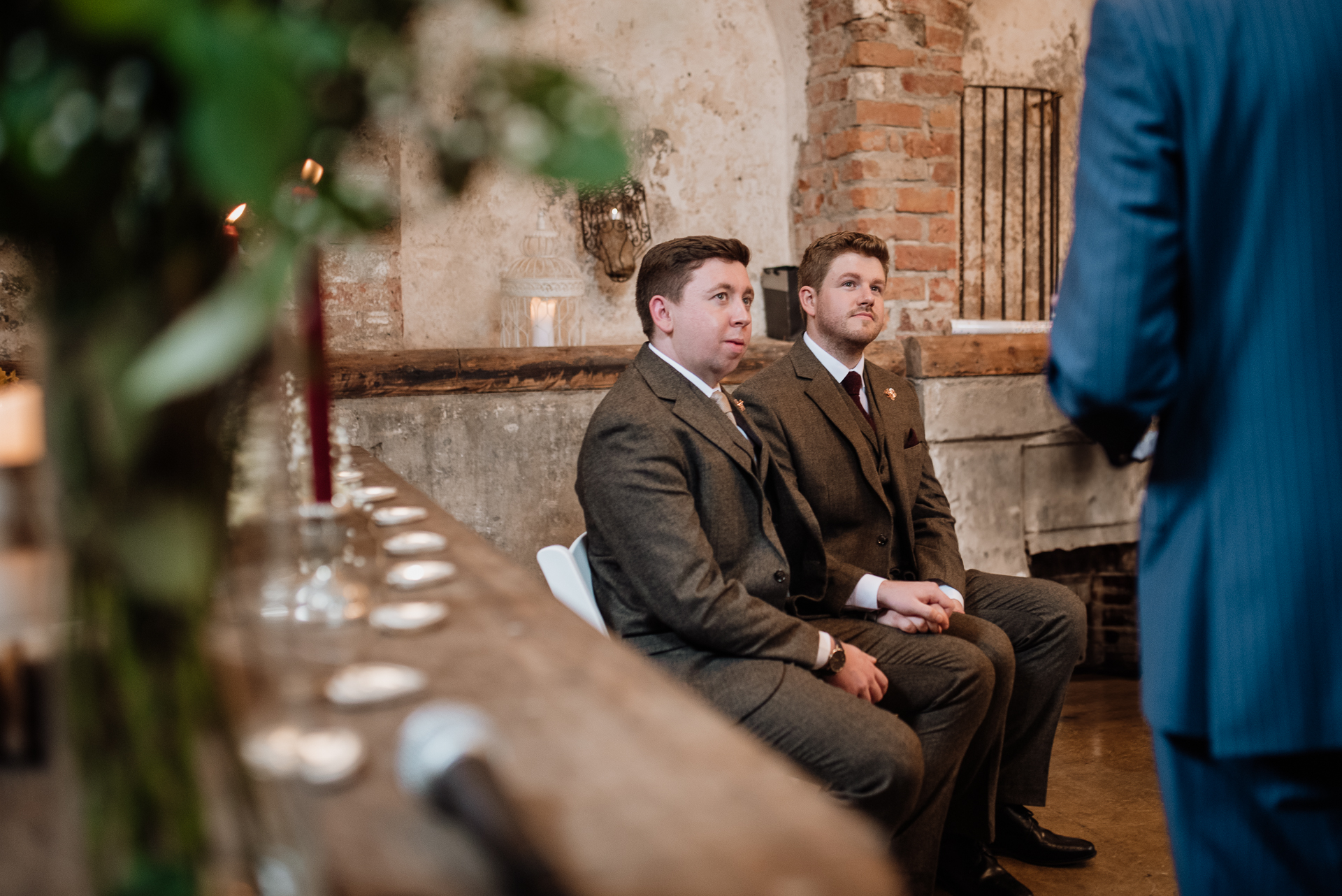 A couple of men sitting at a table with food and drinks