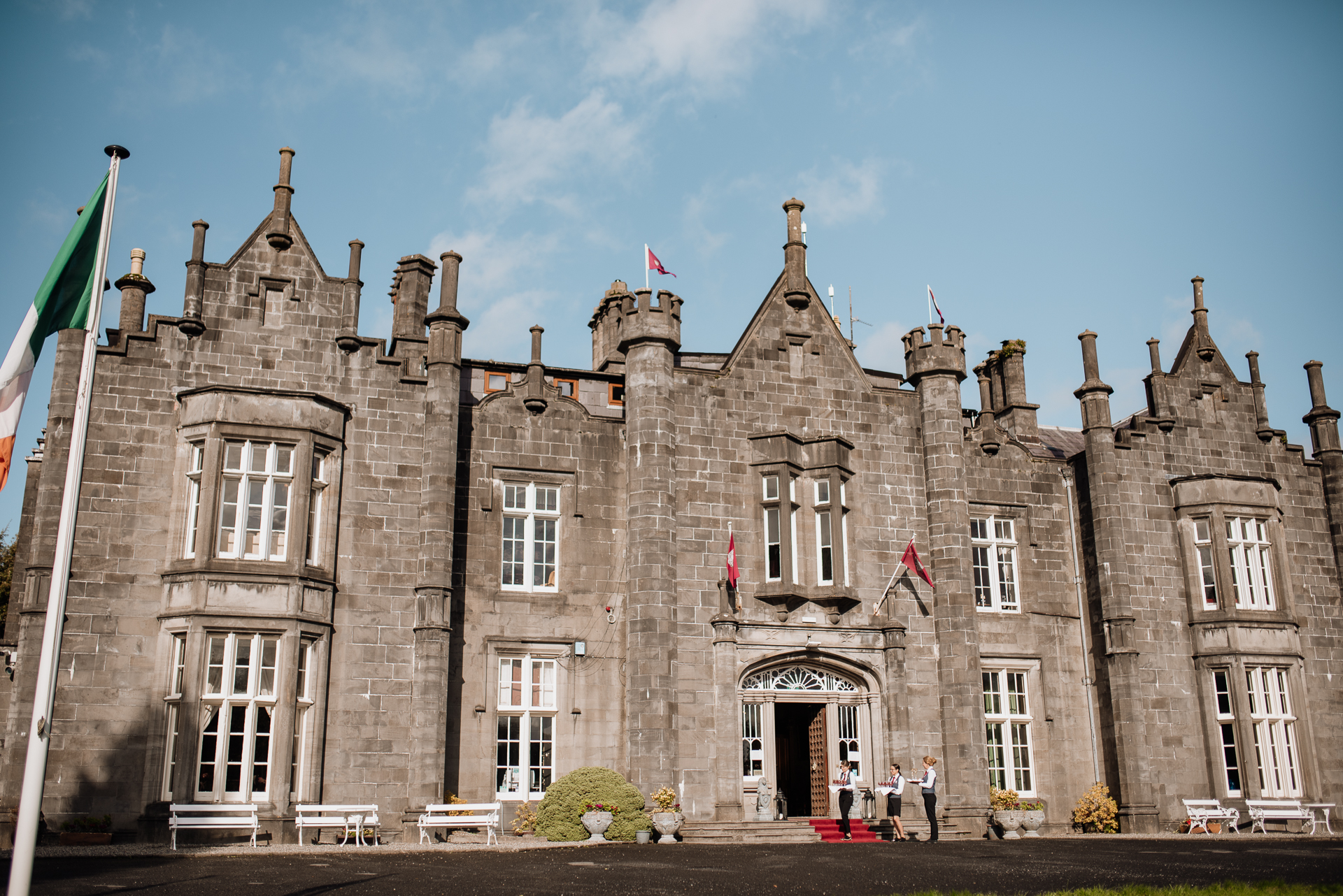 A stone building with flags