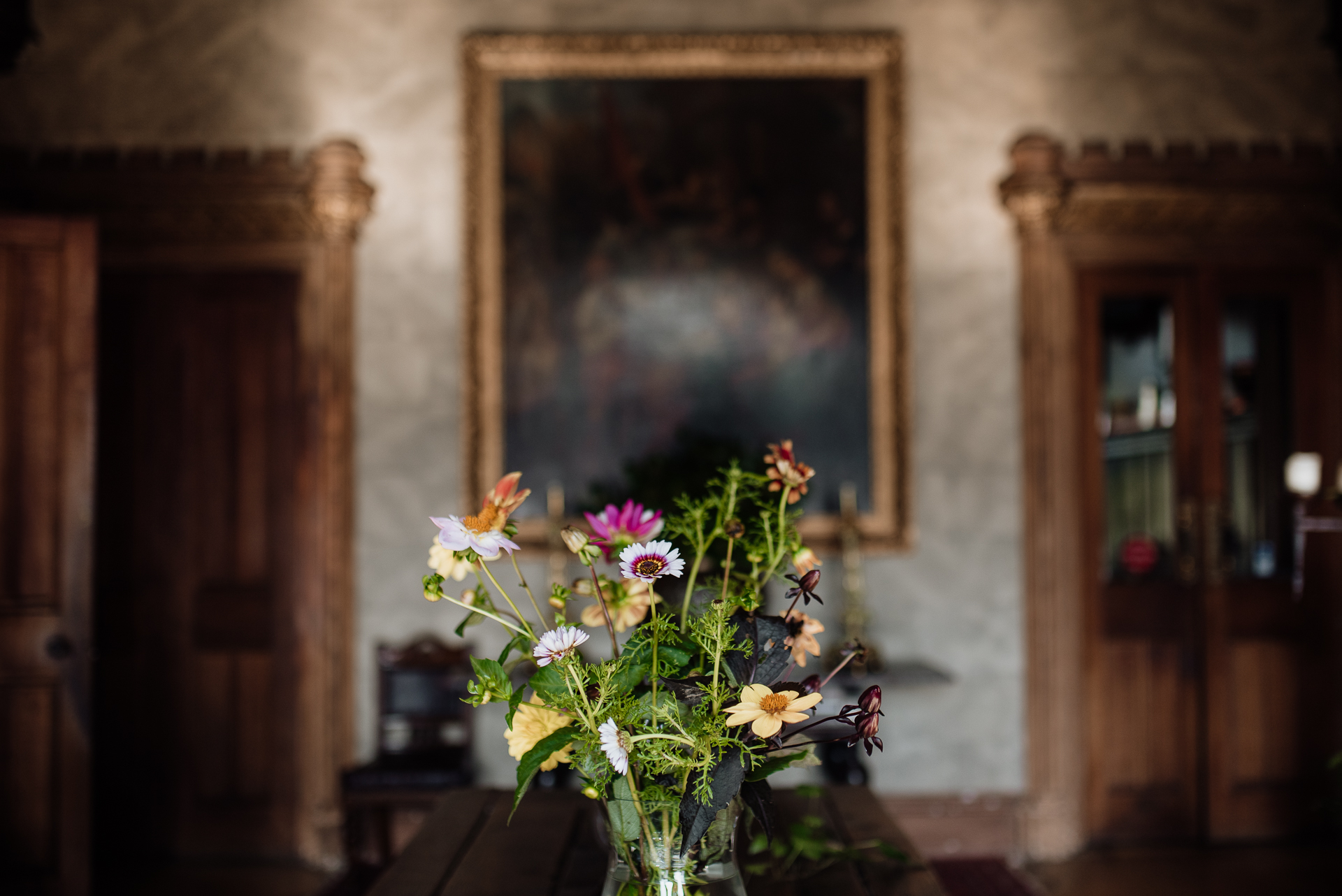 A vase of flowers in front of a painting