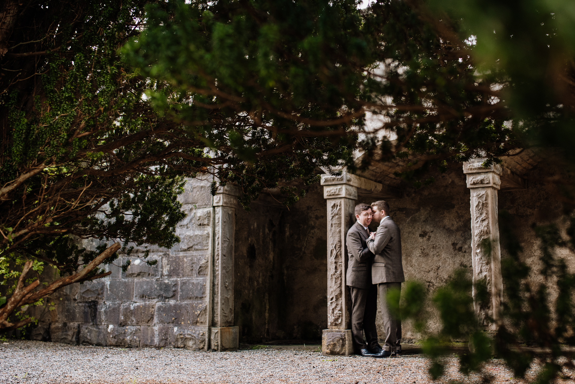 Two men standing in front of a stone wall