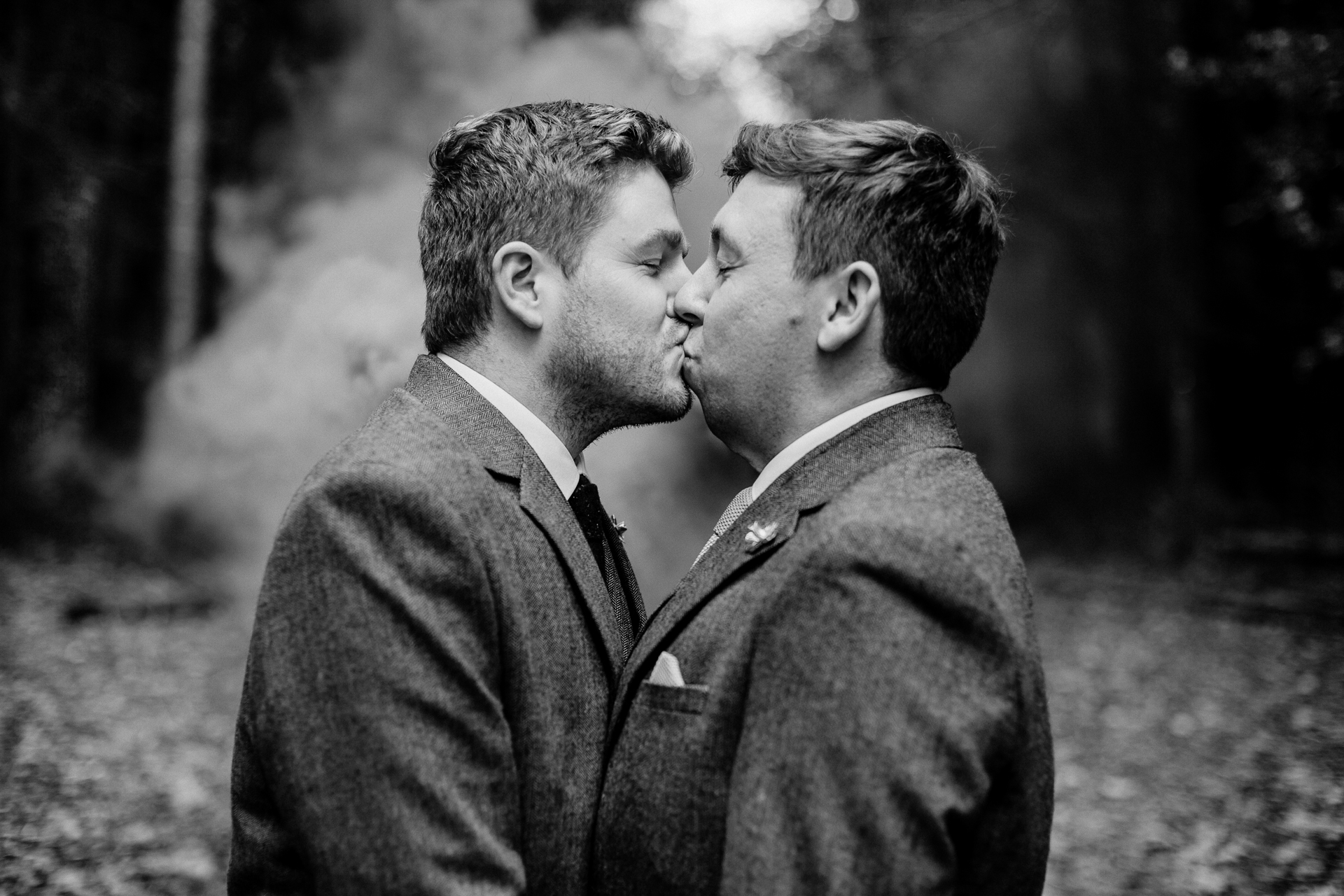 Two men in suits kissing