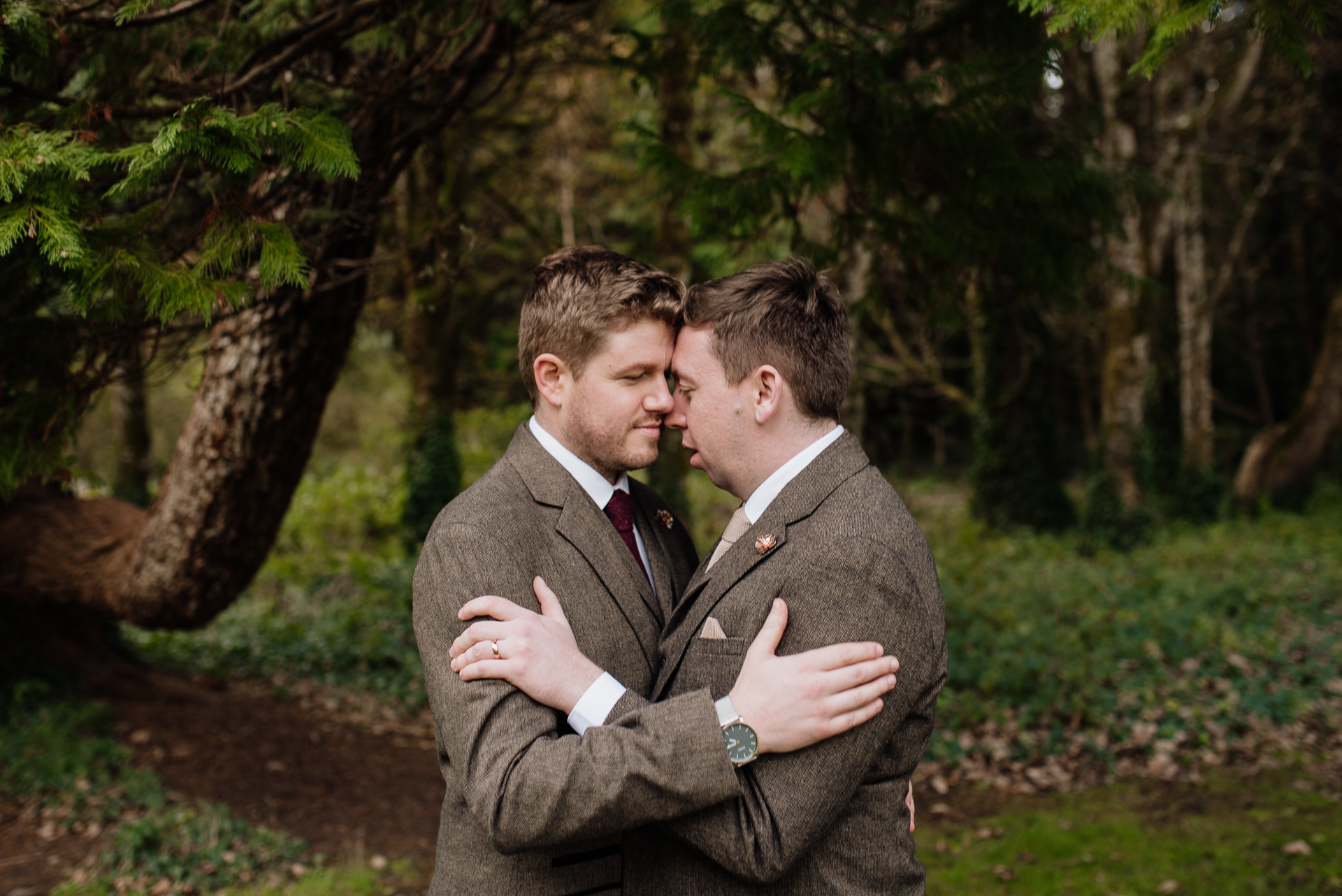 Two men in suits hugging