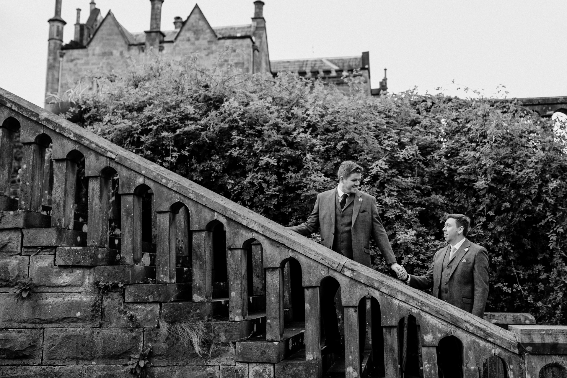 A couple of men standing on a bridge over a river